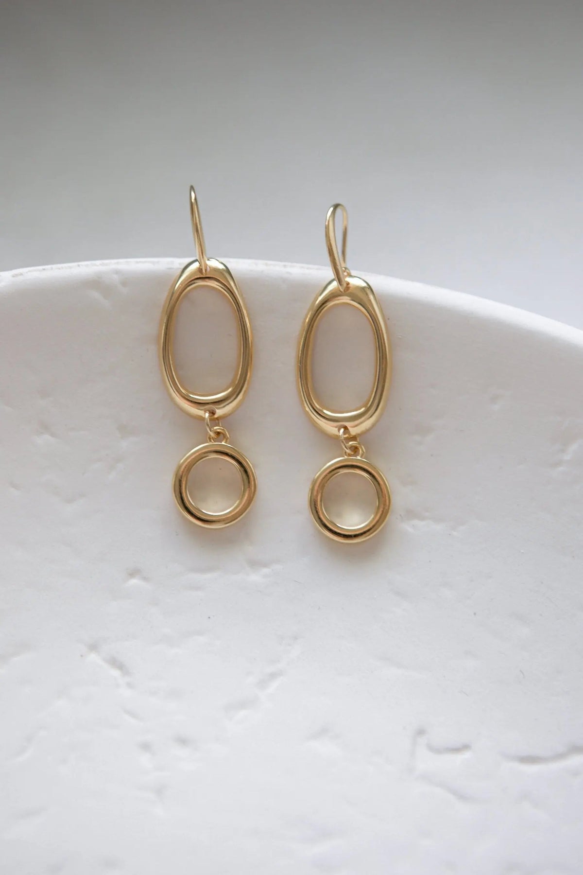 Classic Oval Earrings in gold-tone metal with smooth oval hoops and small round drop charms