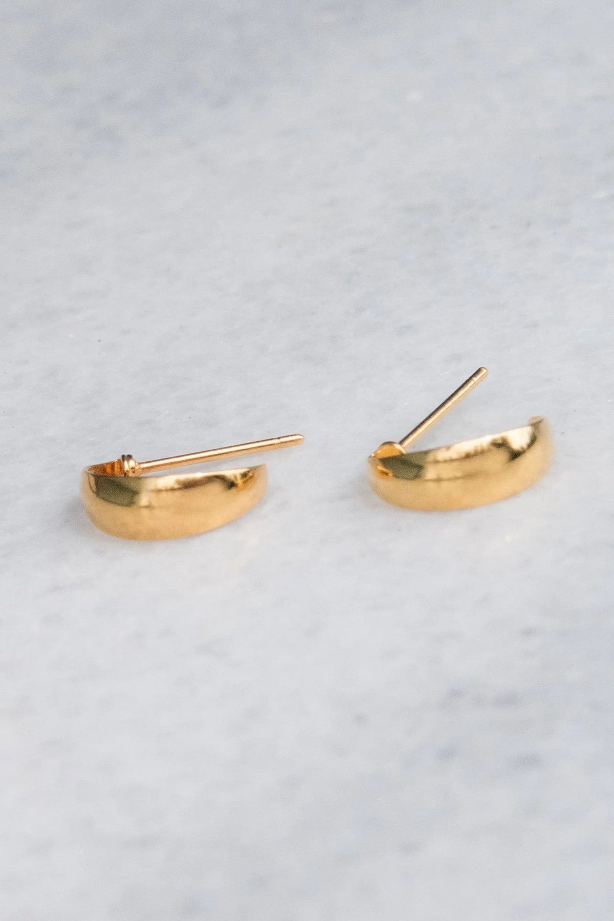 Crescent moon Hoops in polished gold-tone metal, small curved half-moon studs with straight posts.