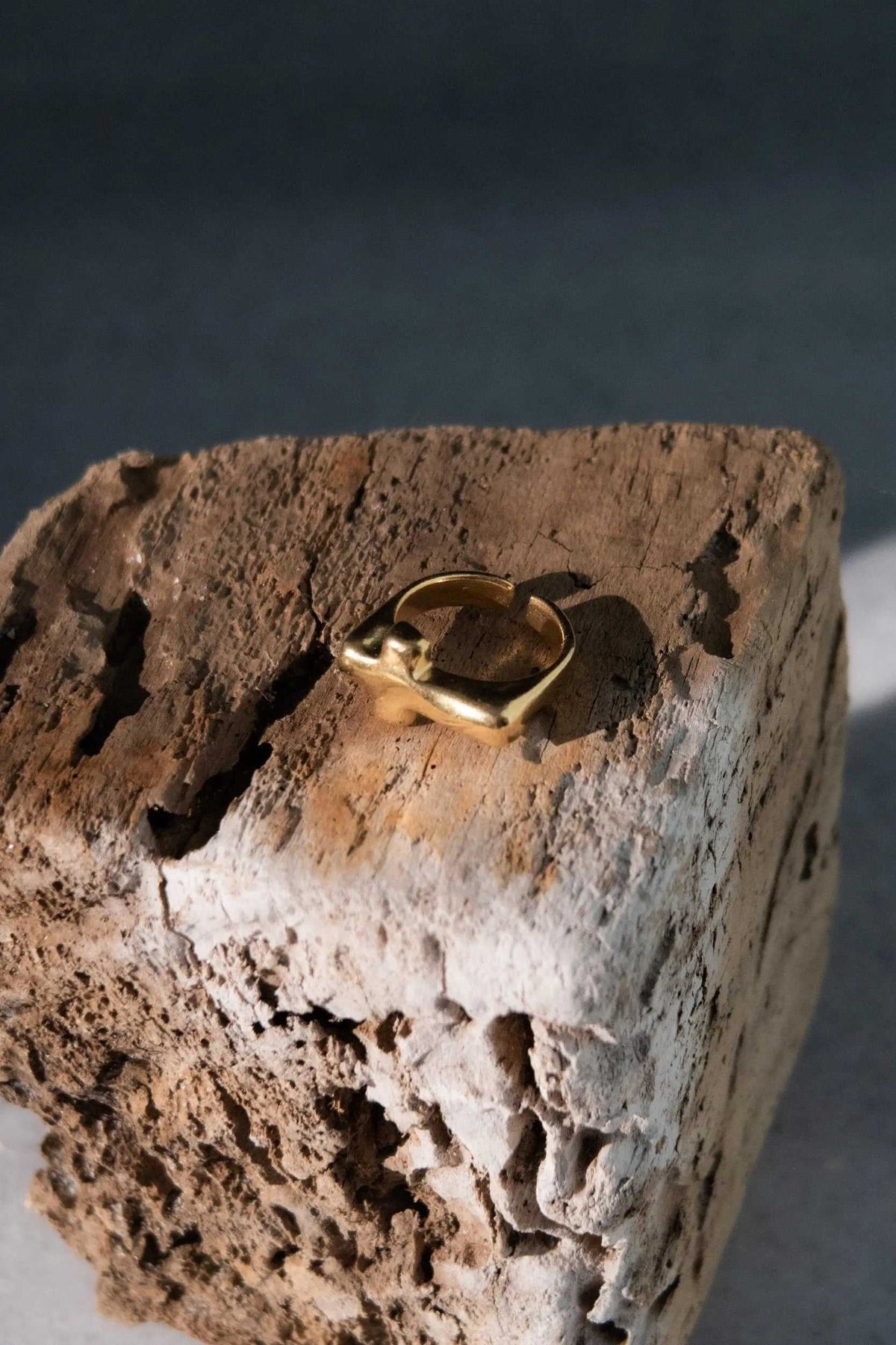 Cross RING in gold-tone metal with a smooth, sculptural band and an open adjustable design