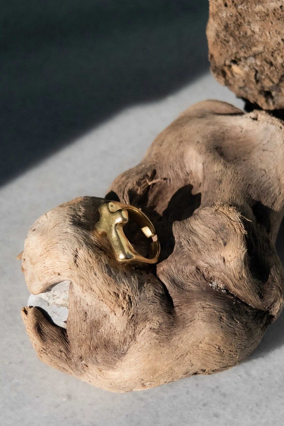 Cross RING in polished gold-tone metal with a sculptural raised cross motif and an adjustable open band