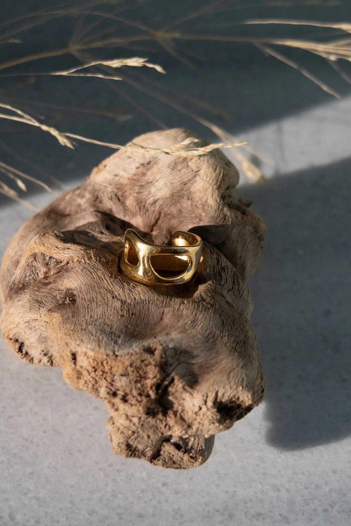 Deformed Organic RING in polished gold-tone metal with an irregular sculptural band and a rounded open center