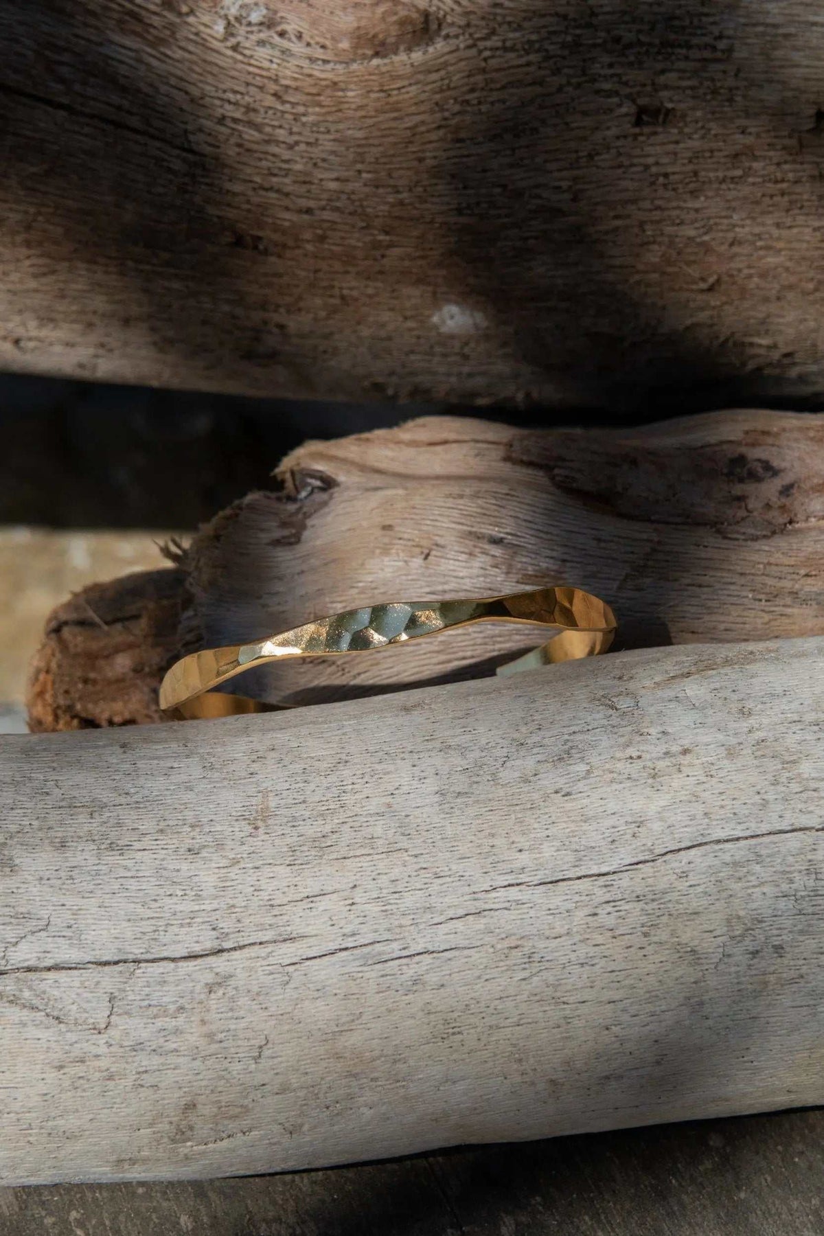 Delicate Hammered Bracelet in gold-toned metal with an uneven, gently hammered surface and slim open cuff shape