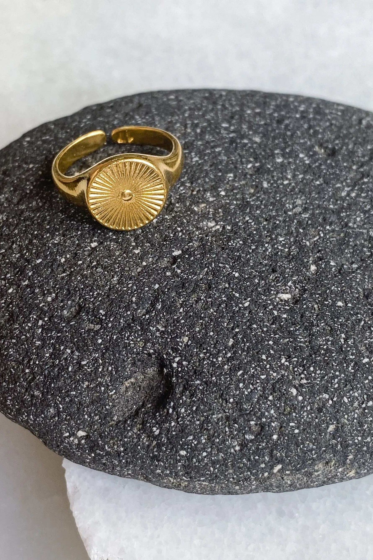DELOS RING in gold-tone metal with a round sunburst motif and an adjustable open band
