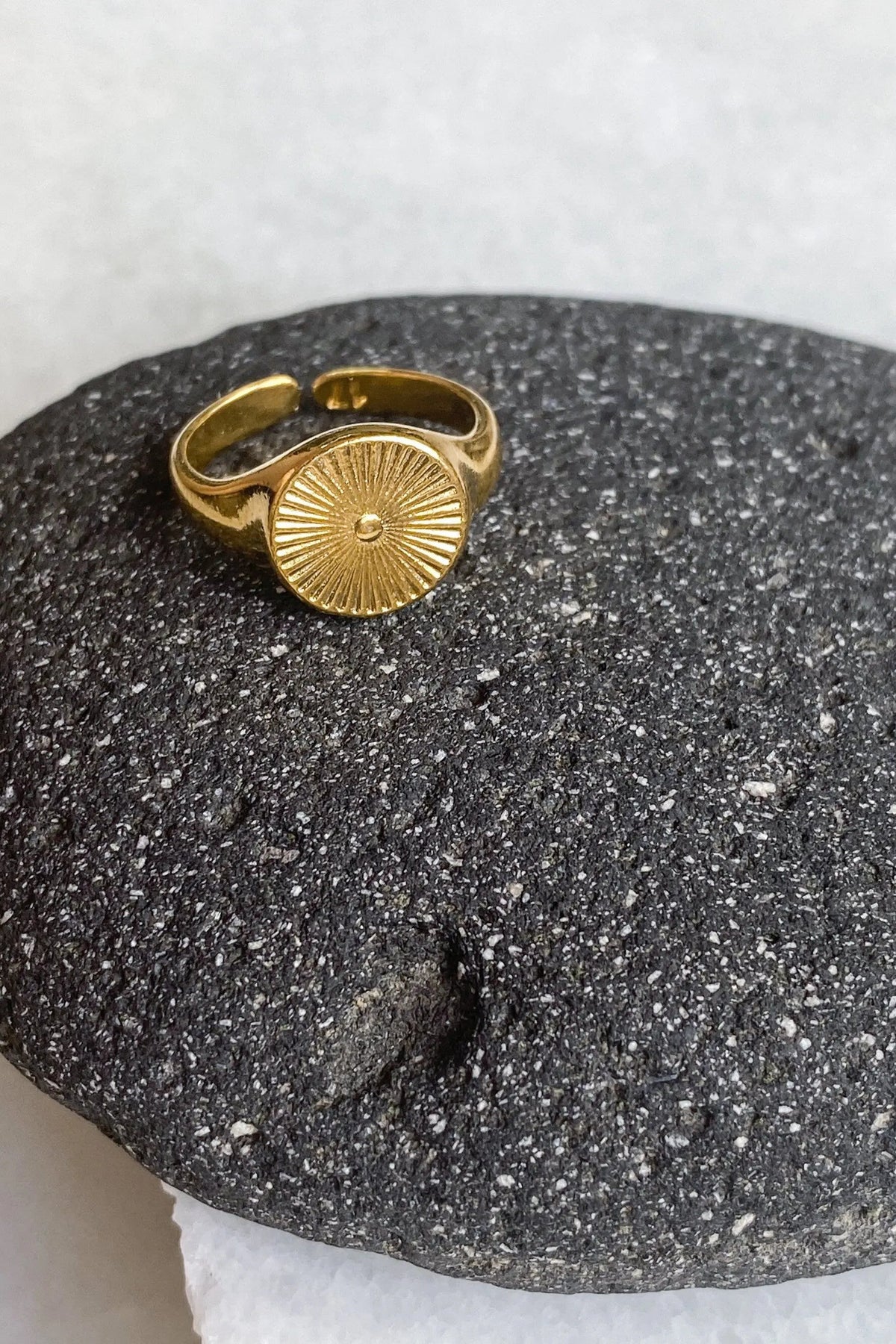 DELOS RING in gold-tone metal with a round sunburst motif and open, slightly adjustable band