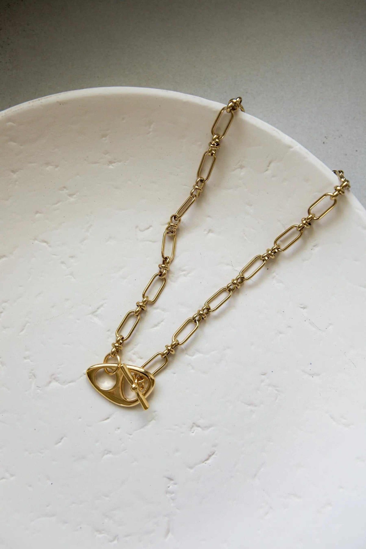 DESMOS Bracelet gold-tone steel chain with elongated links and a distinctive saddle-style buckle closure