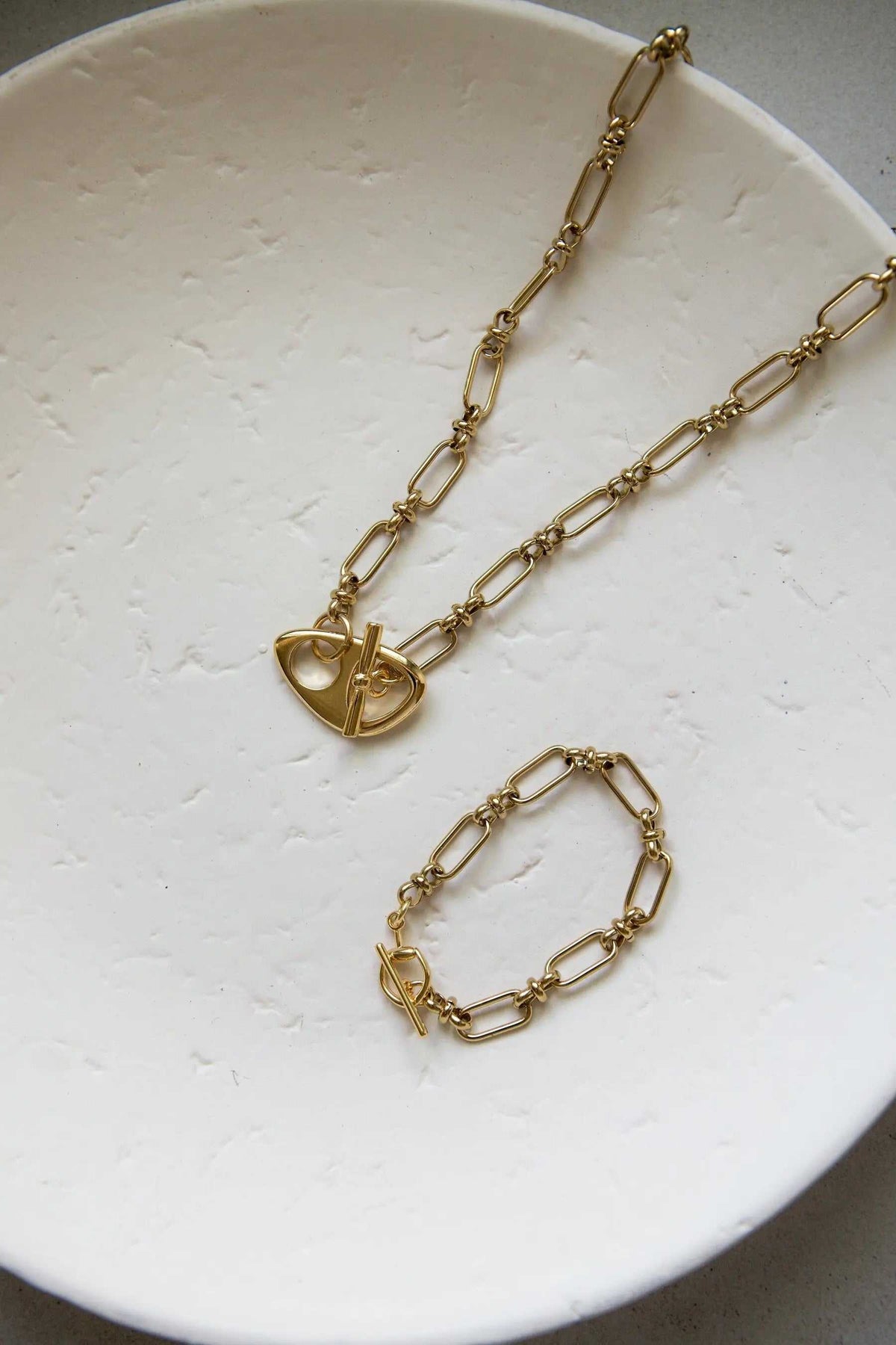 DESMOS Bracelet gold-tone steel chain with elongated links and a distinctive saddle buckle clasp