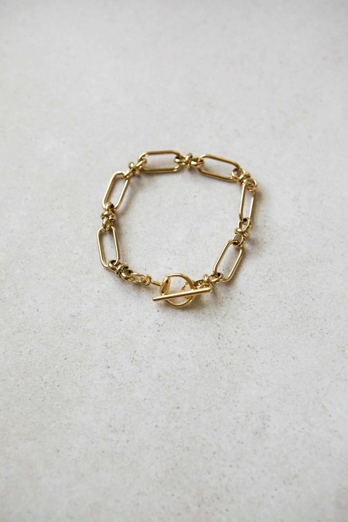 DESMOS Bracelet in gold-tone steel with elongated oval links and a distinctive saddle-style buckle closure