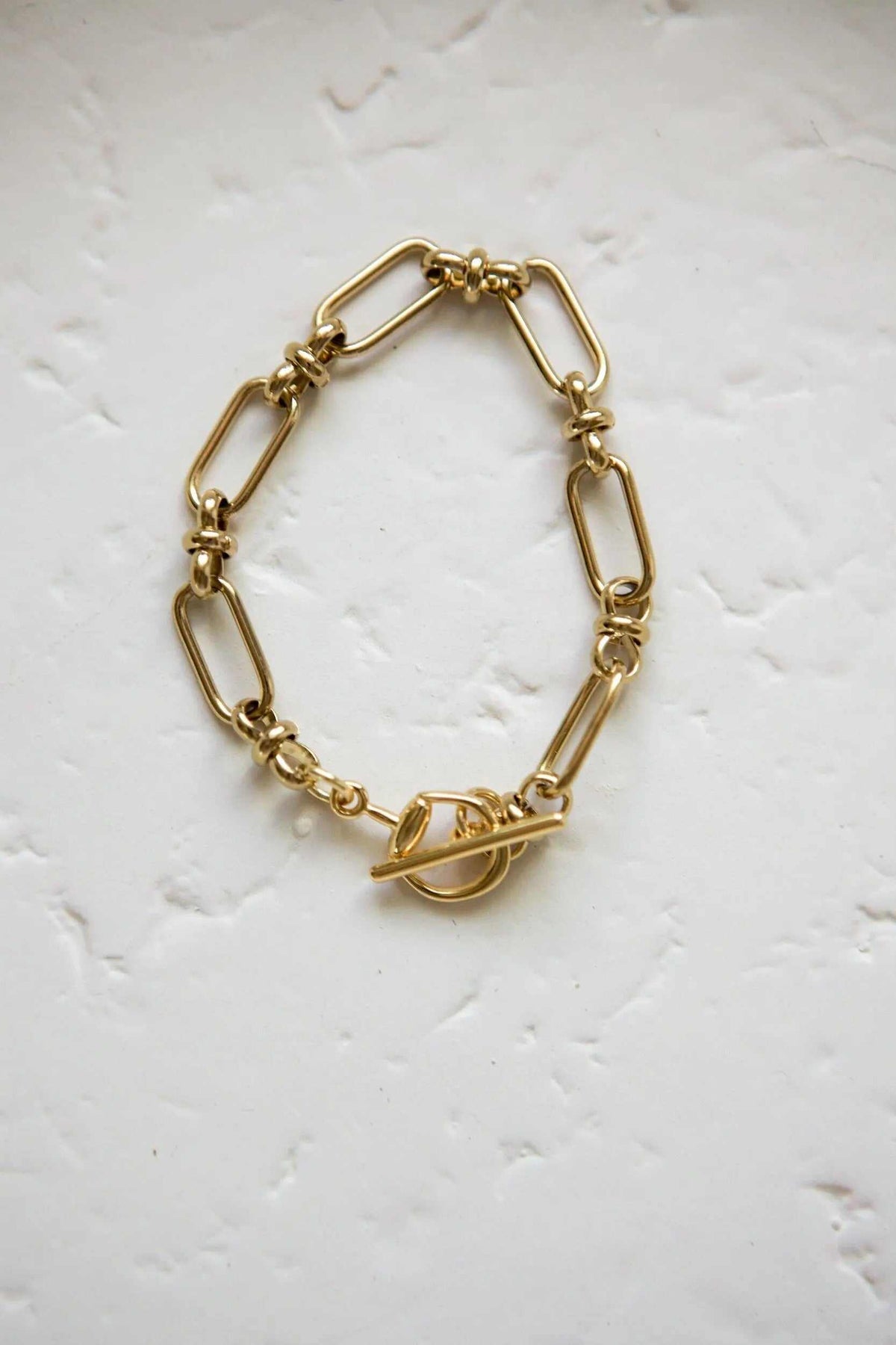 DESMOS Bracelet in polished gold-tone metal with elongated oval links and a distinctive toggle bar clasp