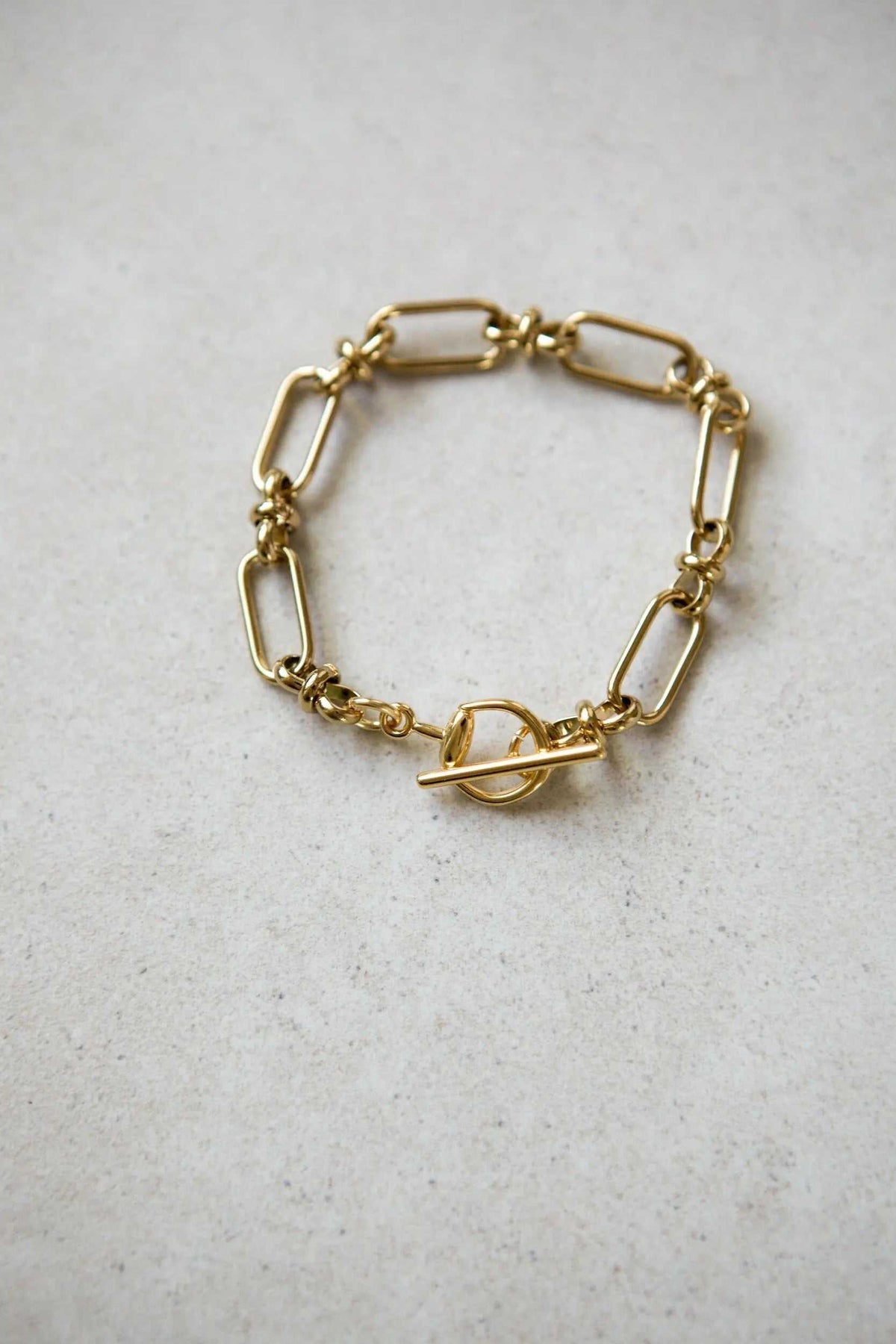 DESMOS Bracelet in gold-tone metal with elongated rectangular links and a distinctive toggle clasp