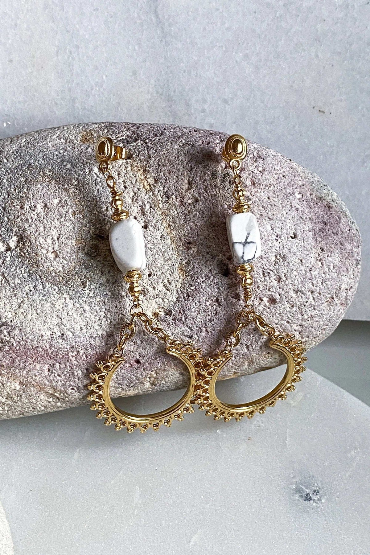ÉRIS EARRINGS are long gold-tone brass drops with white stone beads and ornate open crescent-shaped charms