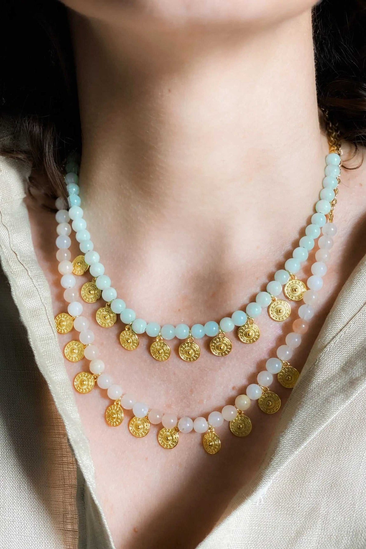 ERSA NECKLACE with pale aqua and peach-toned gemstone beads, layered with small round gold-tone charms