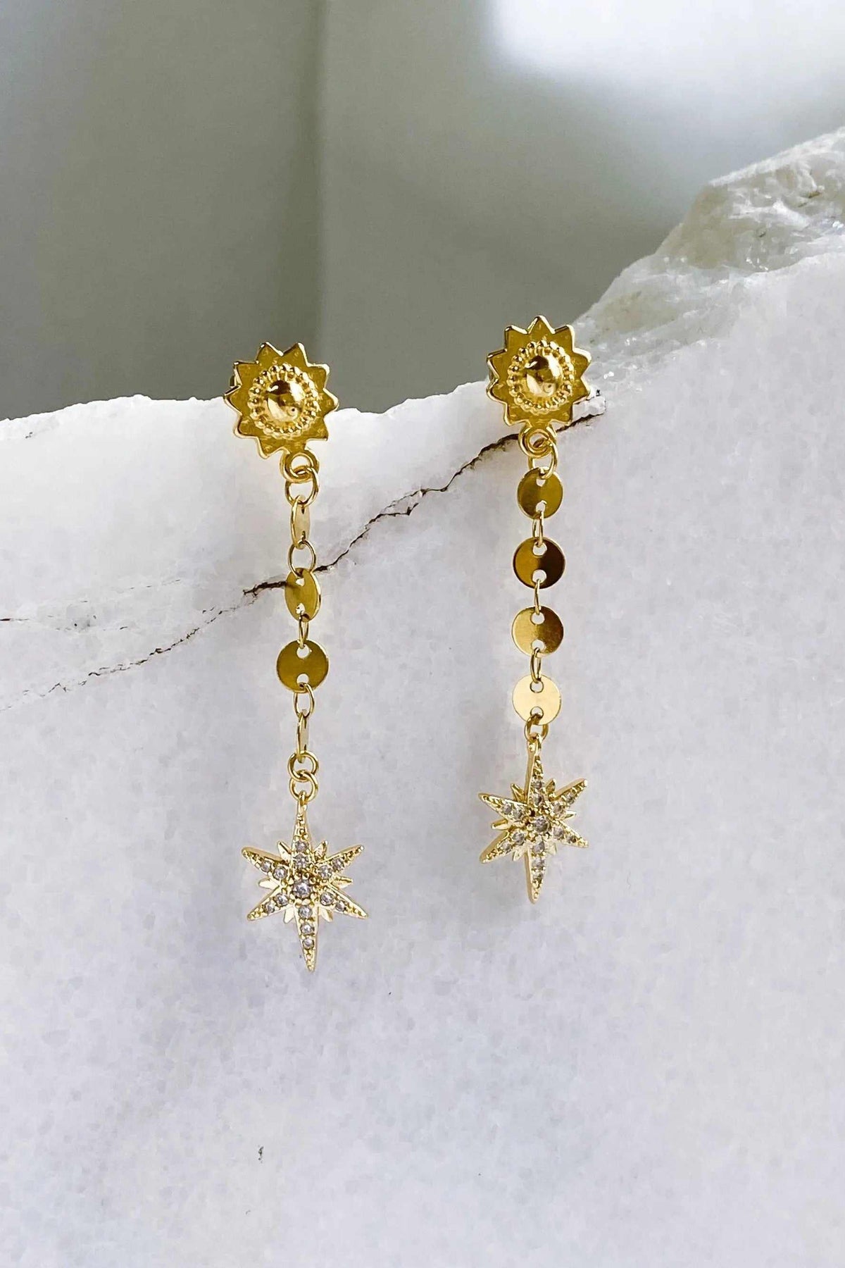ESTRADE Earrings in gold-toned metal with celestial sunburst studs, dangling chain links, beads and starburst charms