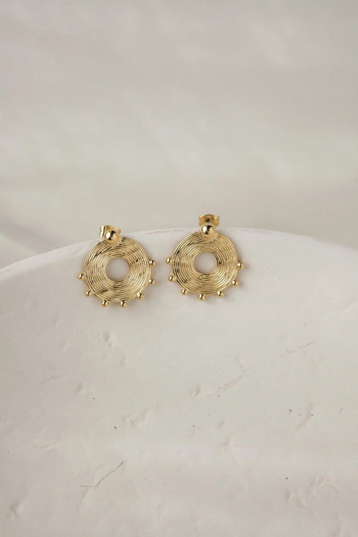 Ethnic round Earrings in gold-tone metal with circular coiled wire designs, open centers, and small bead accents