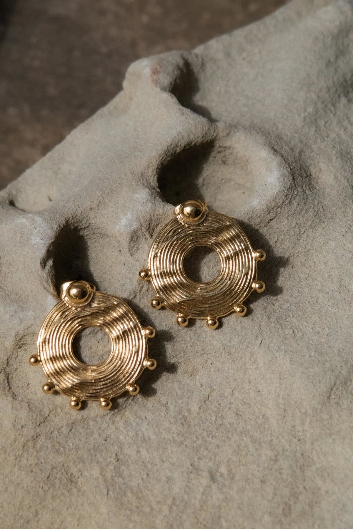 Ethnic round Earrings in gold-toned metal, with concentric ridged rings, open centres and small ball accents