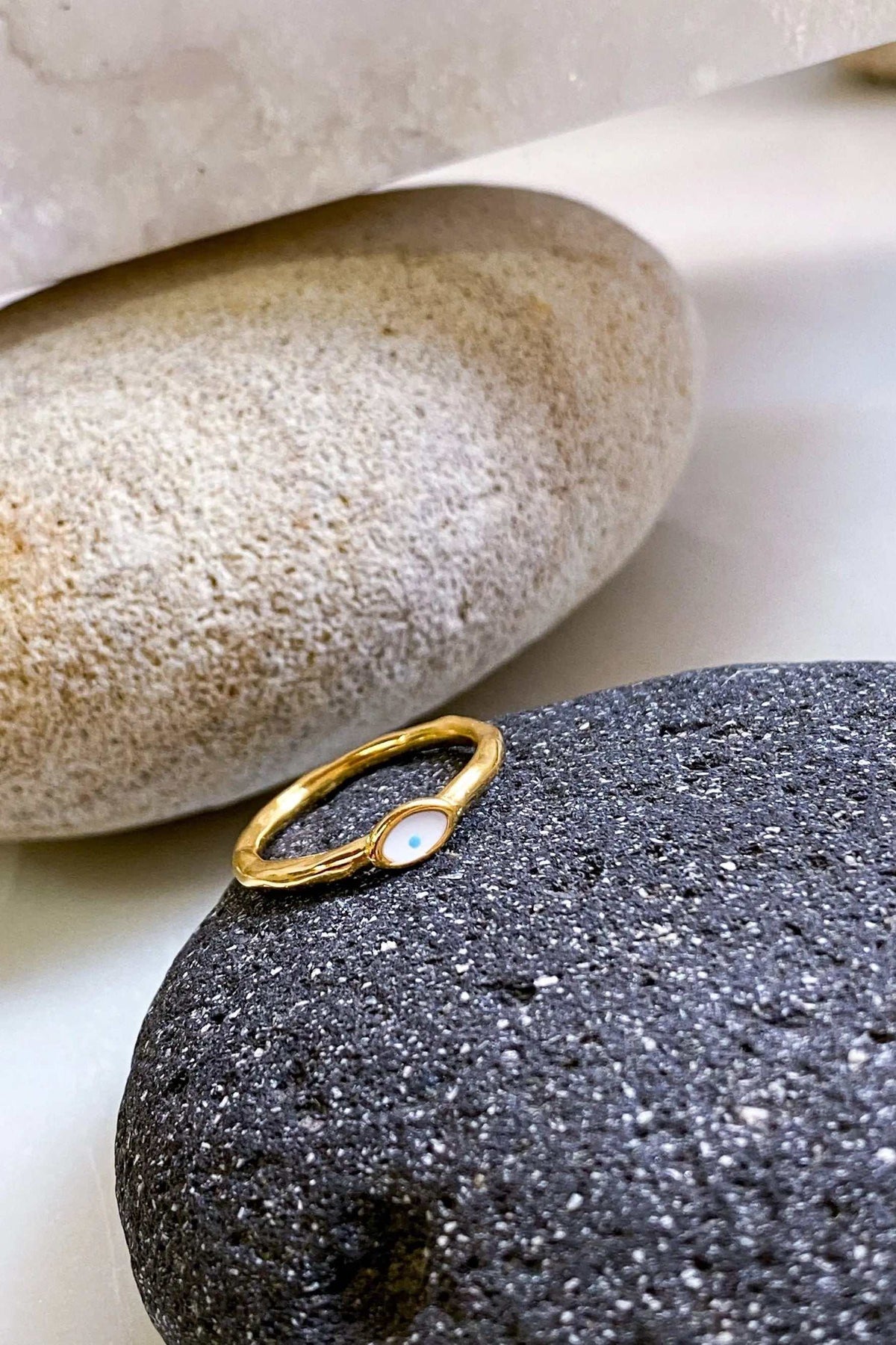 EYE Evil eye ring in gold with a slim open band and a small white oval eye detail set at the center