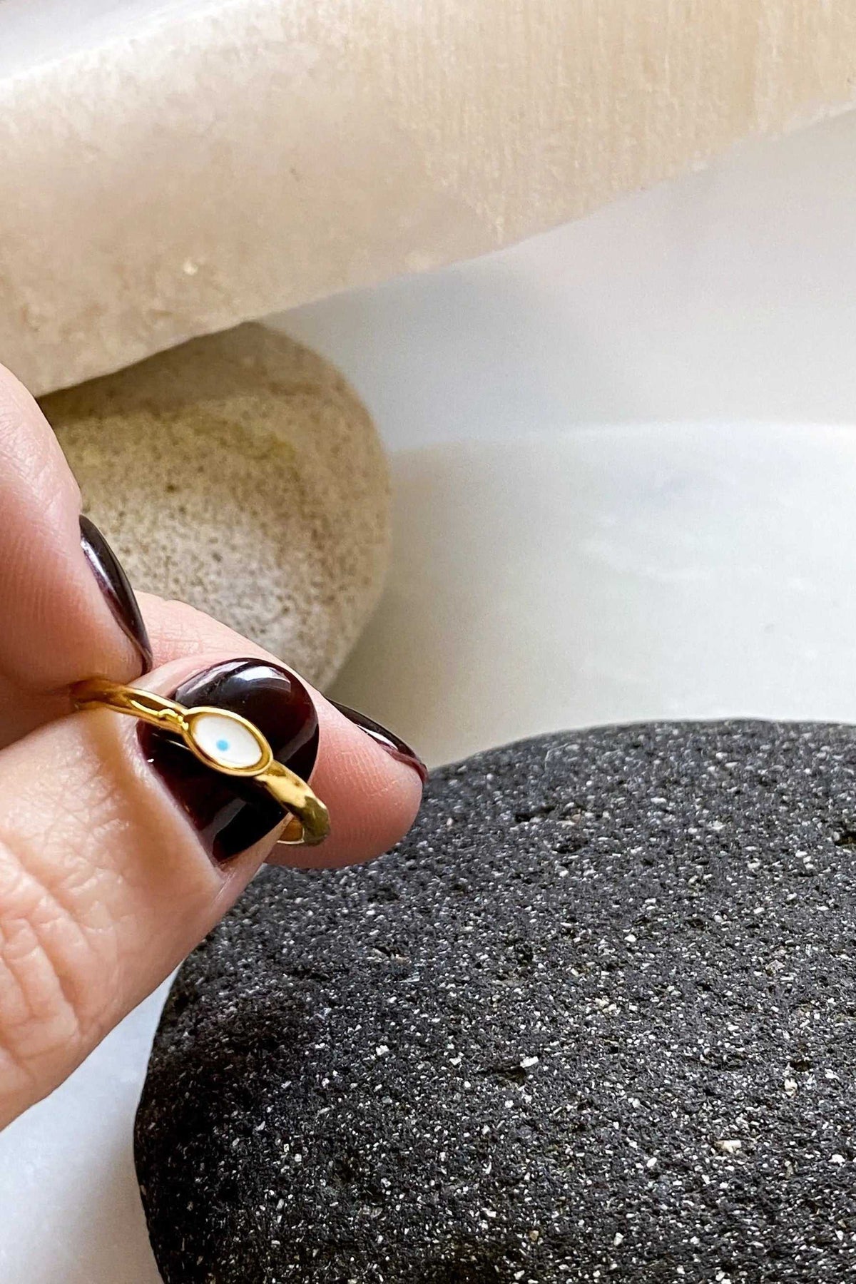 EYE Evil eye ring, gold-toned band with a small oval white eye detail worn on a finger