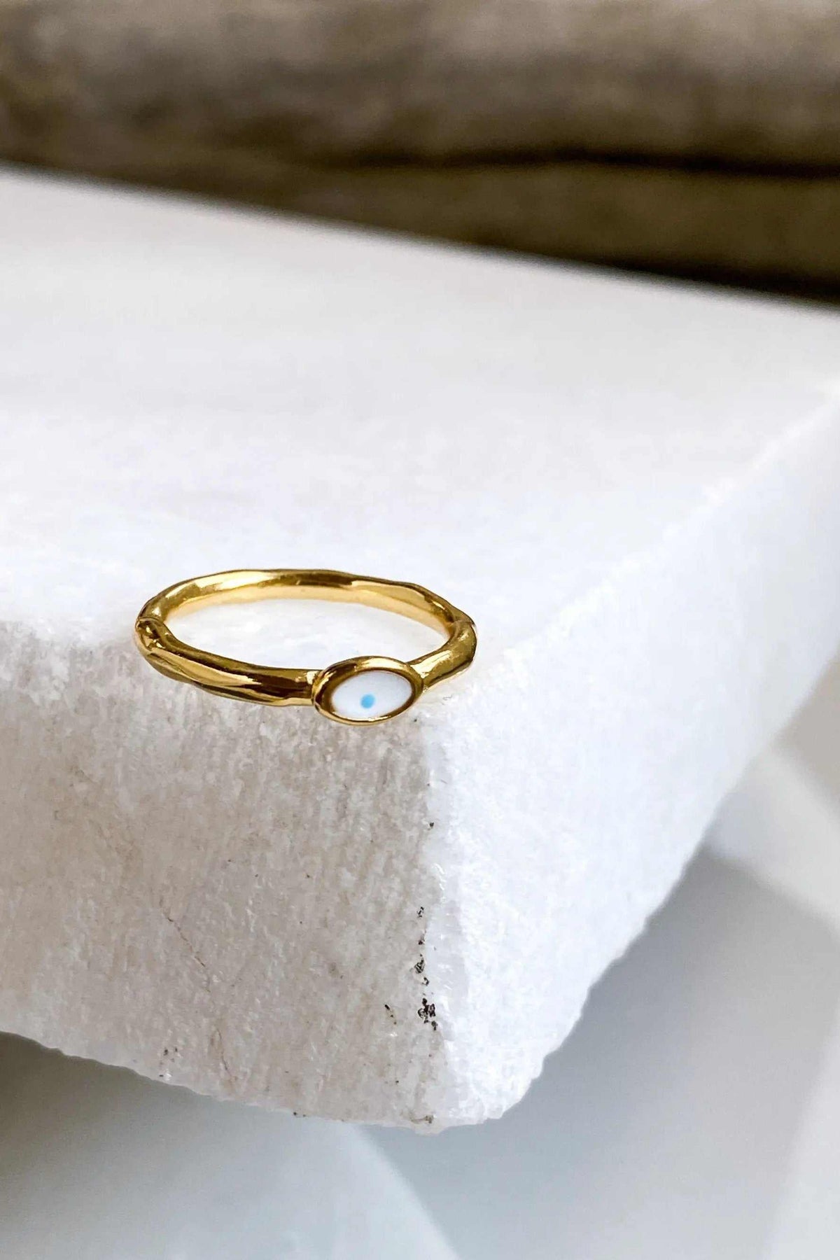 EYE Evil eye ring in polished gold-tone metal, featuring a slim band and an oval white eye motif with a blue center