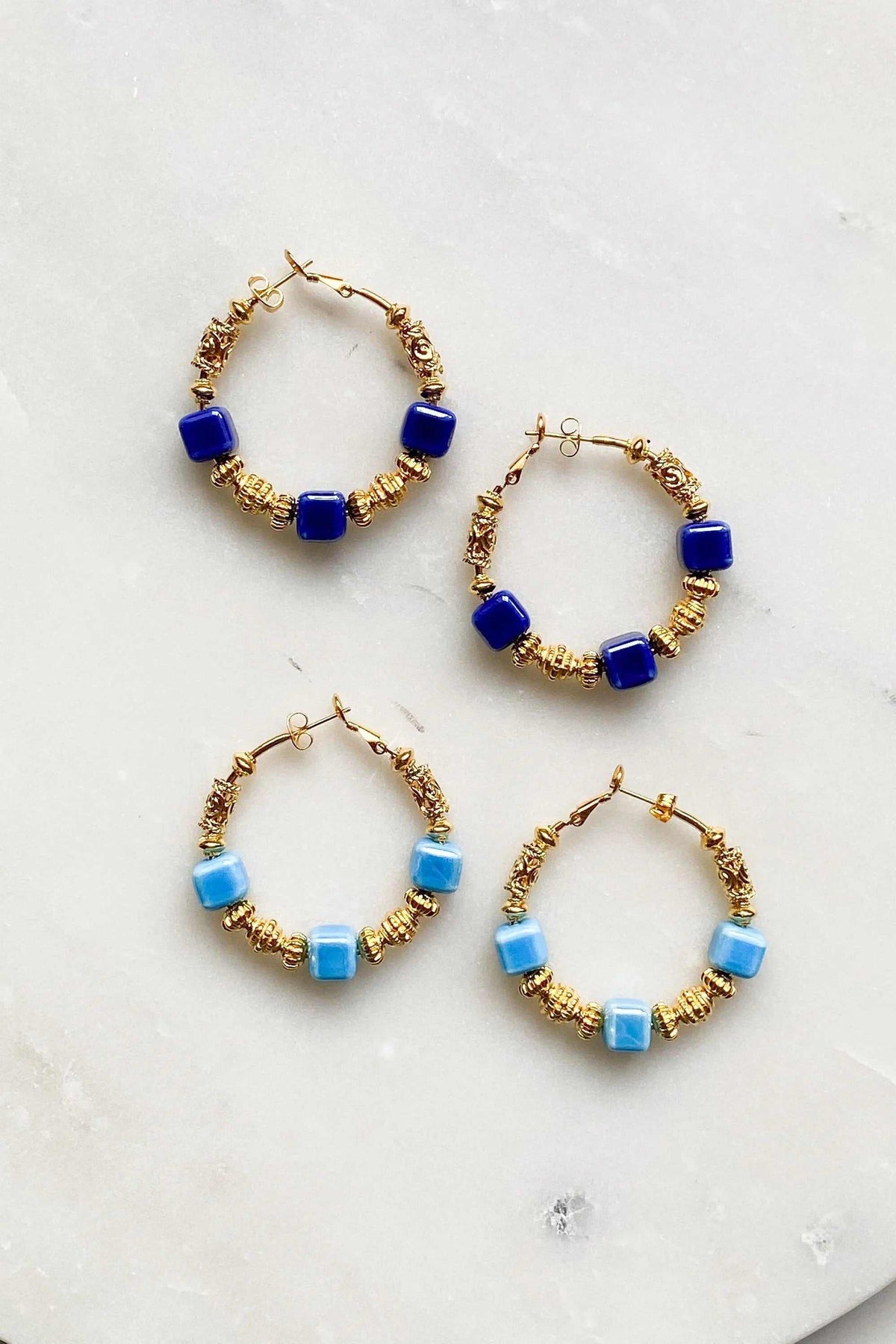 GÉA EARRINGS gold-tone hoop earrings with blue and light blue ceramic cube beads and textured detailing