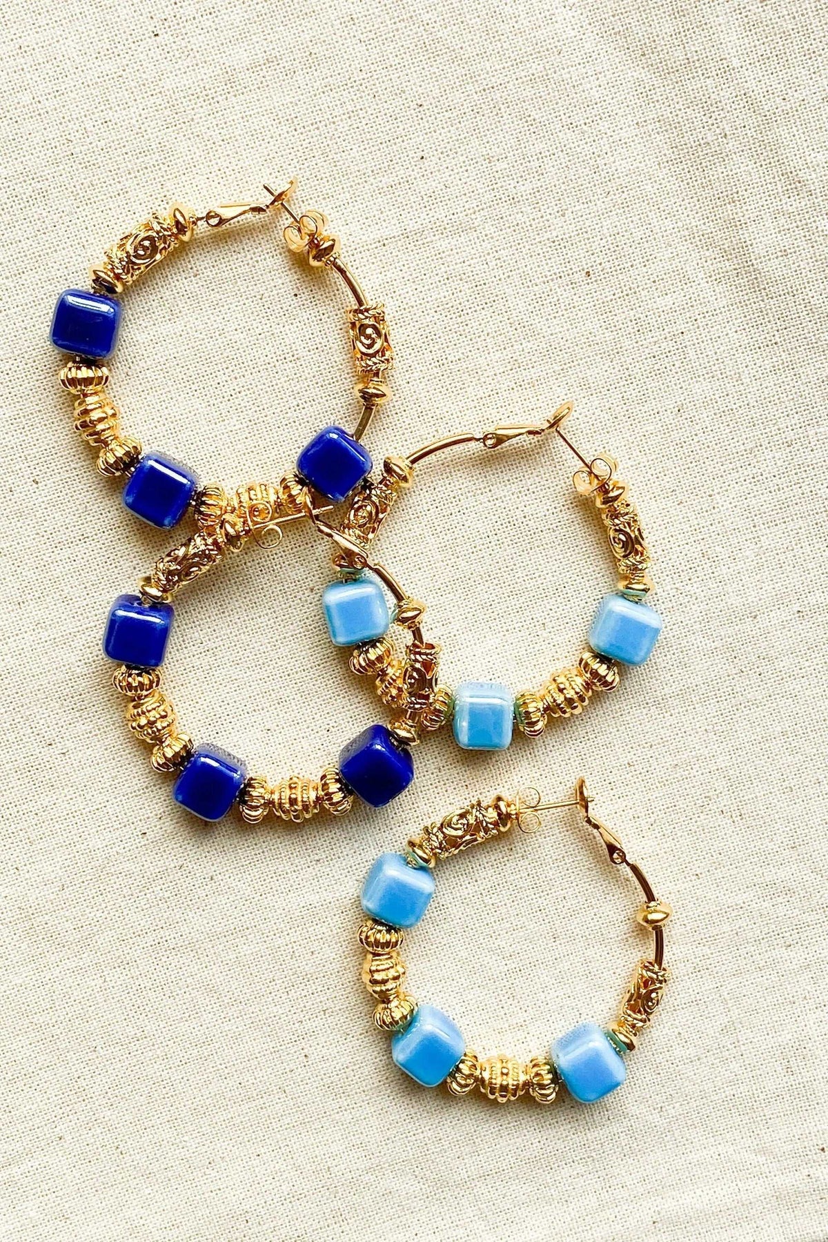 GÉA EARRINGS with gold-tone wrapped hoop wires and glossy cobalt blue and light blue ceramic cube beads