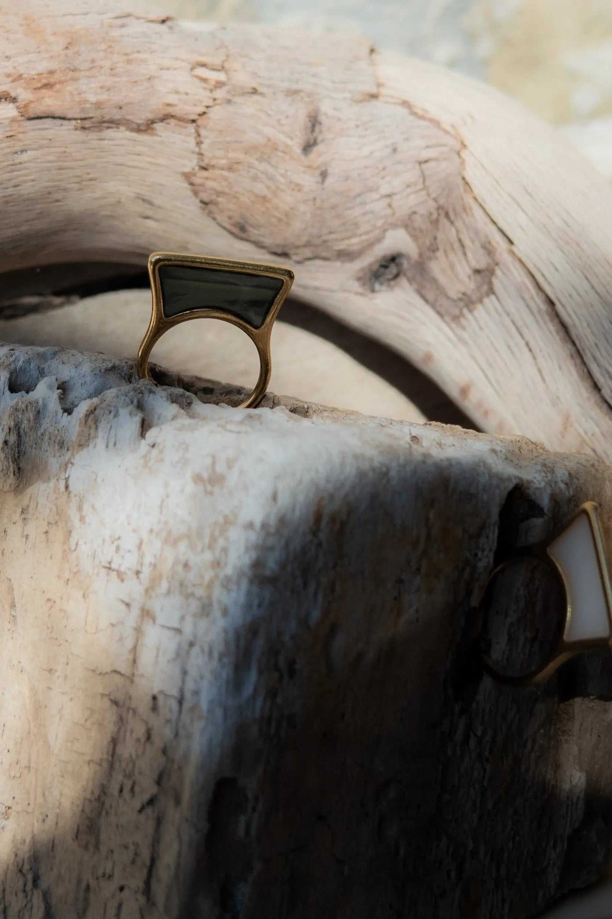 Geometric modern ring with a gold-tone metal band and a black rectangular stained-glass top