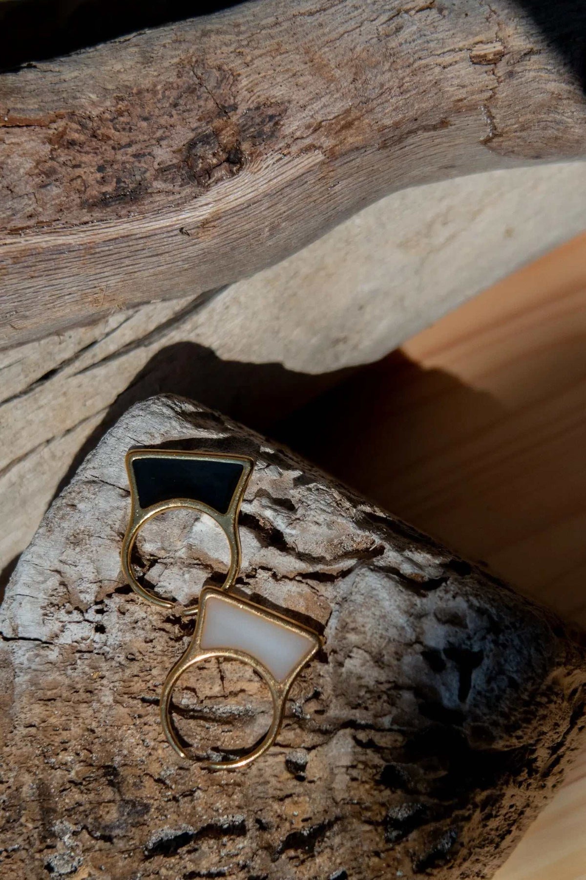 Geometric modern ring with gold-tone geometric frames, featuring glossy black and white rectangular inlays and open bands