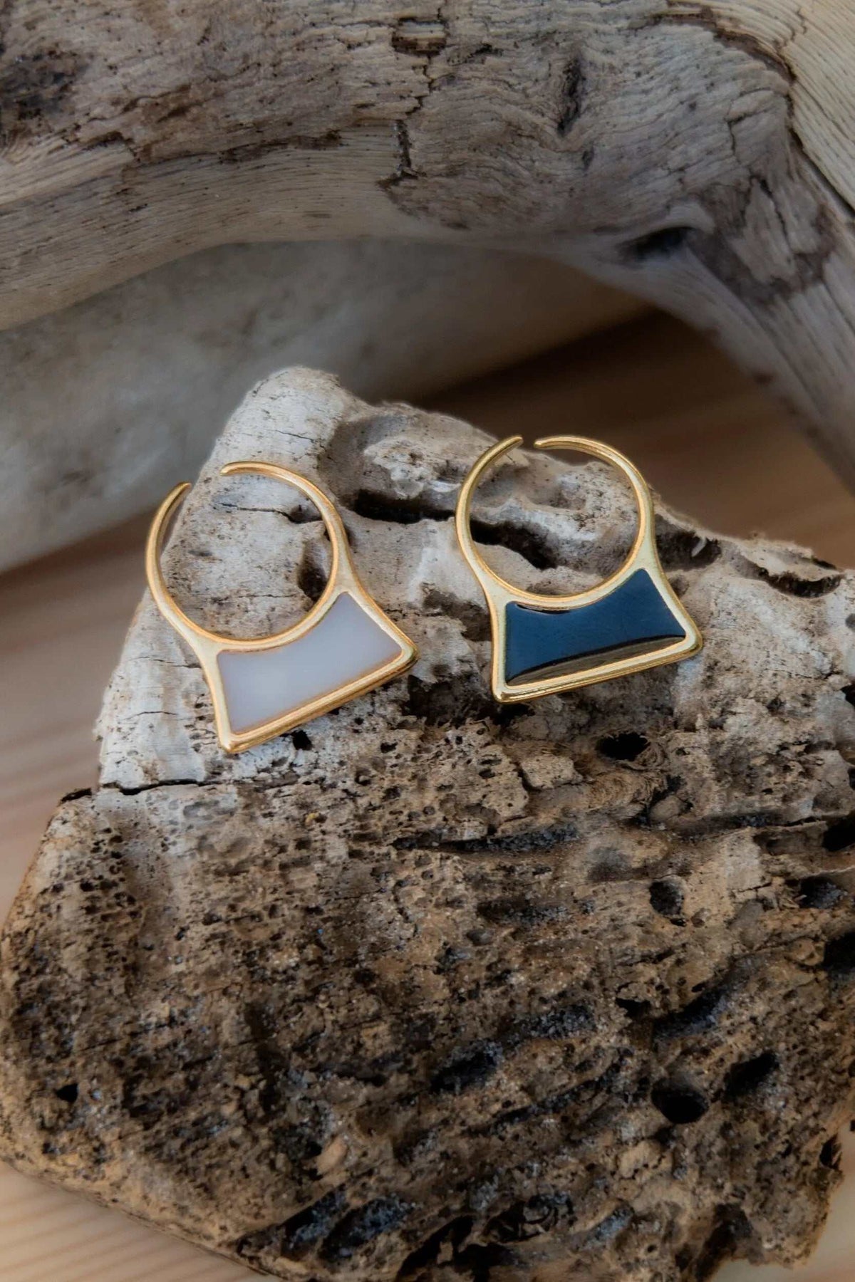 Geometric modern ring with gold-tone geometric frames and smooth pale gray and deep navy inlays