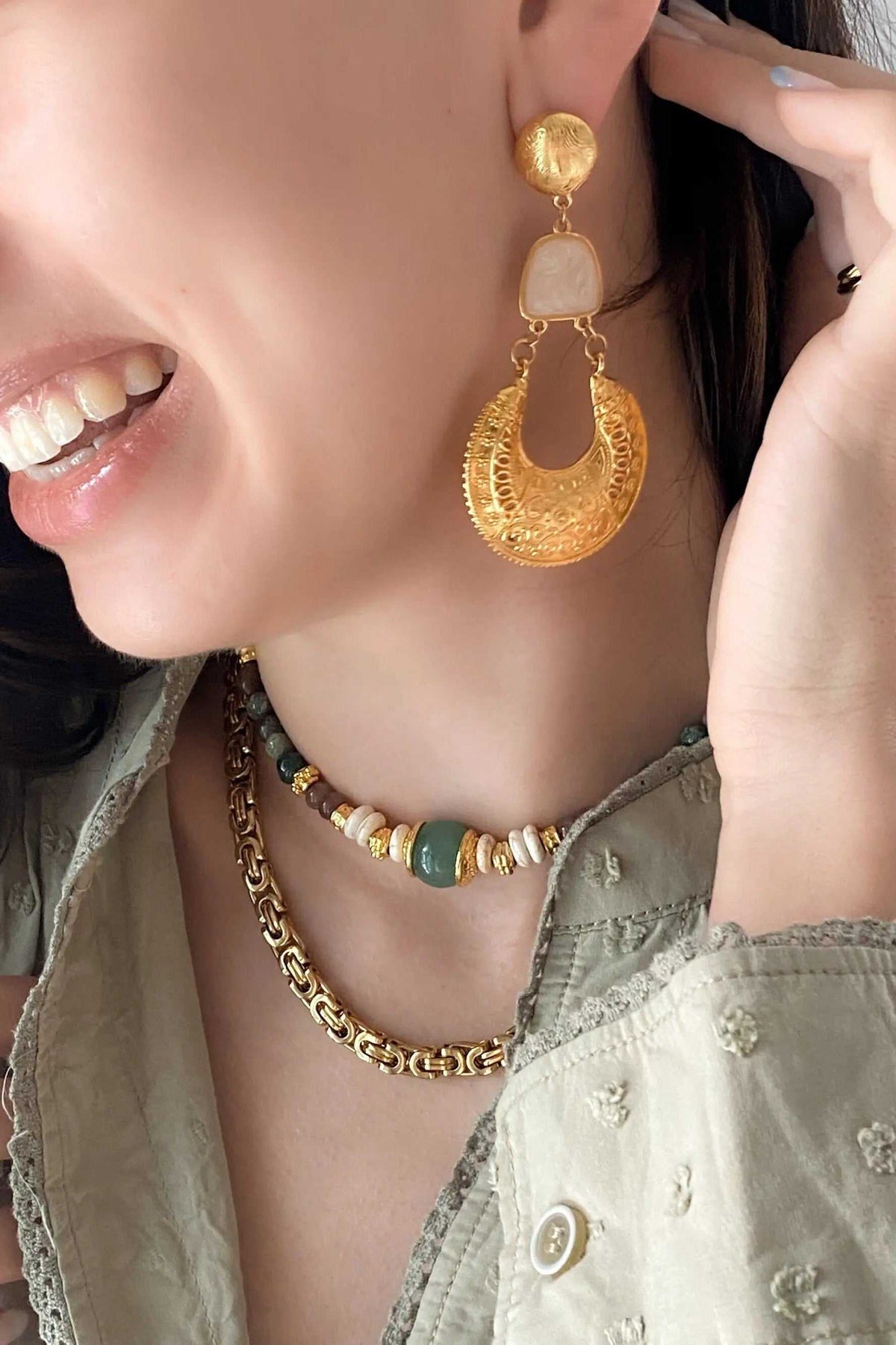 Gold Boho earrings with a cream resin accent, ornate round gold drop and delicate dangling chains