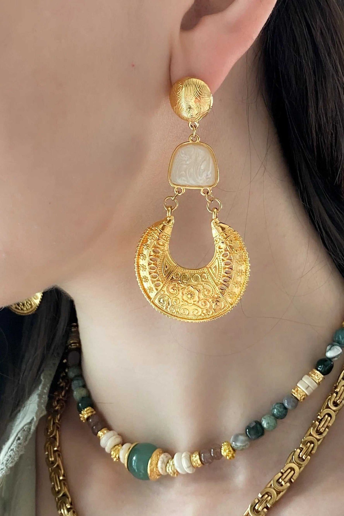 Gold Boho earrings with ornate crescent-shaped filigree drops, round gold studs, and pale rectangular accents