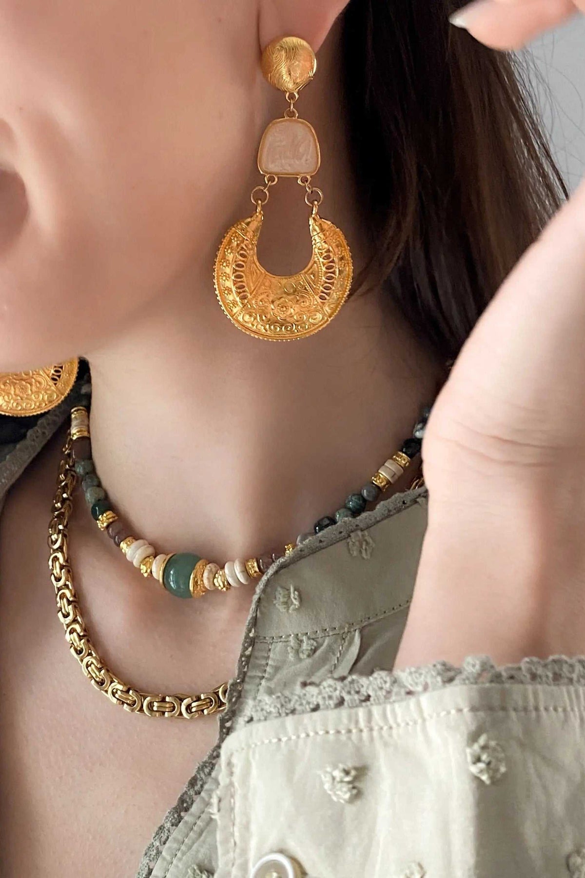 Gold Boho earrings with ornate crescent-shaped gold filigree drops, linked to pale pink stone-like accents and round studs