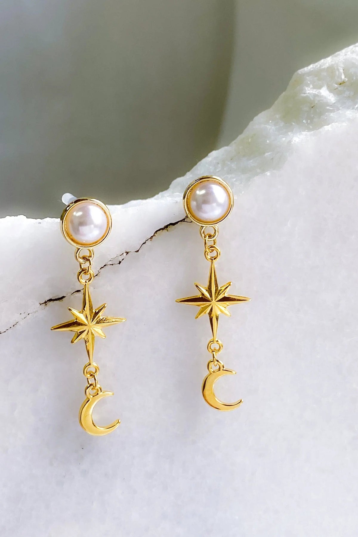 Gold celestial Earrings with pearl studs, gold-tone dangling star and crescent moon charms in a celestial design