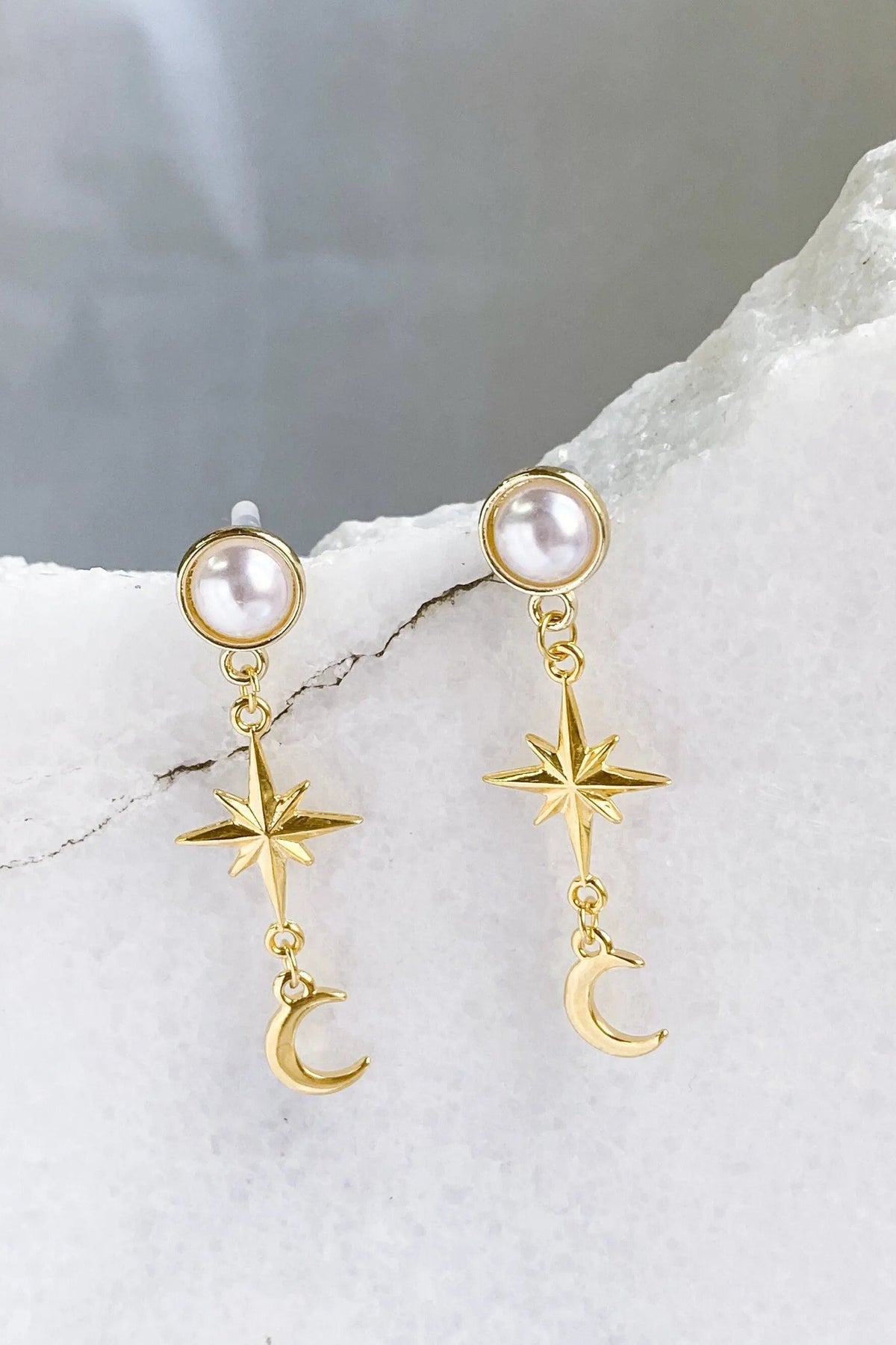 Gold celestial Earrings with pearl studs and delicate gold-toned dangling star and crescent moon charms.