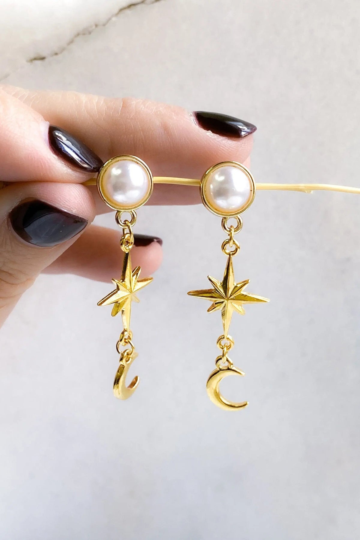 Gold celestial Earrings with pearl studs and dangling polished gold-tone star and crescent moon charms on fine chains