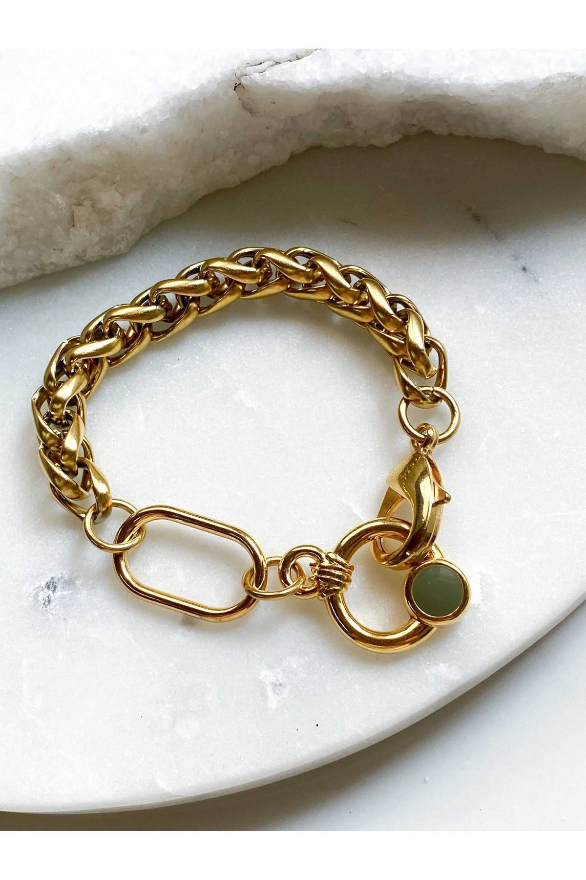 Gold Chain bracelet with a chunky polished gold-tone metal link chain, oversized clasp and small green charm.