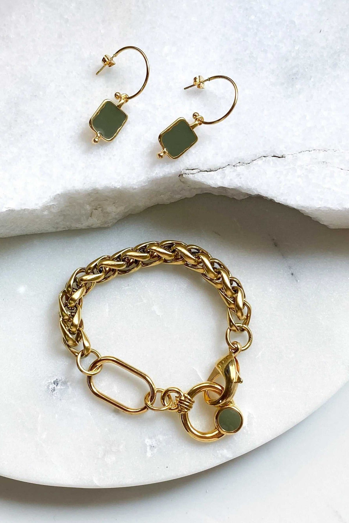 Gold Chain bracelet in chunky gold-tone links with a large toggle clasp and small green charm, paired with matching earrings