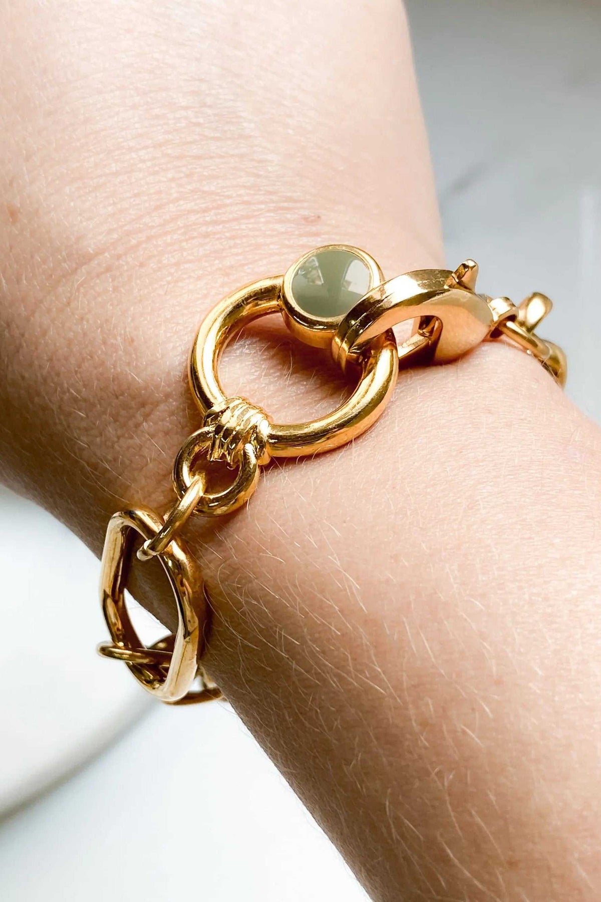 Gold Chain bracelet in polished gold-tone metal with chunky links and a circular clasp topped by a pale green charm