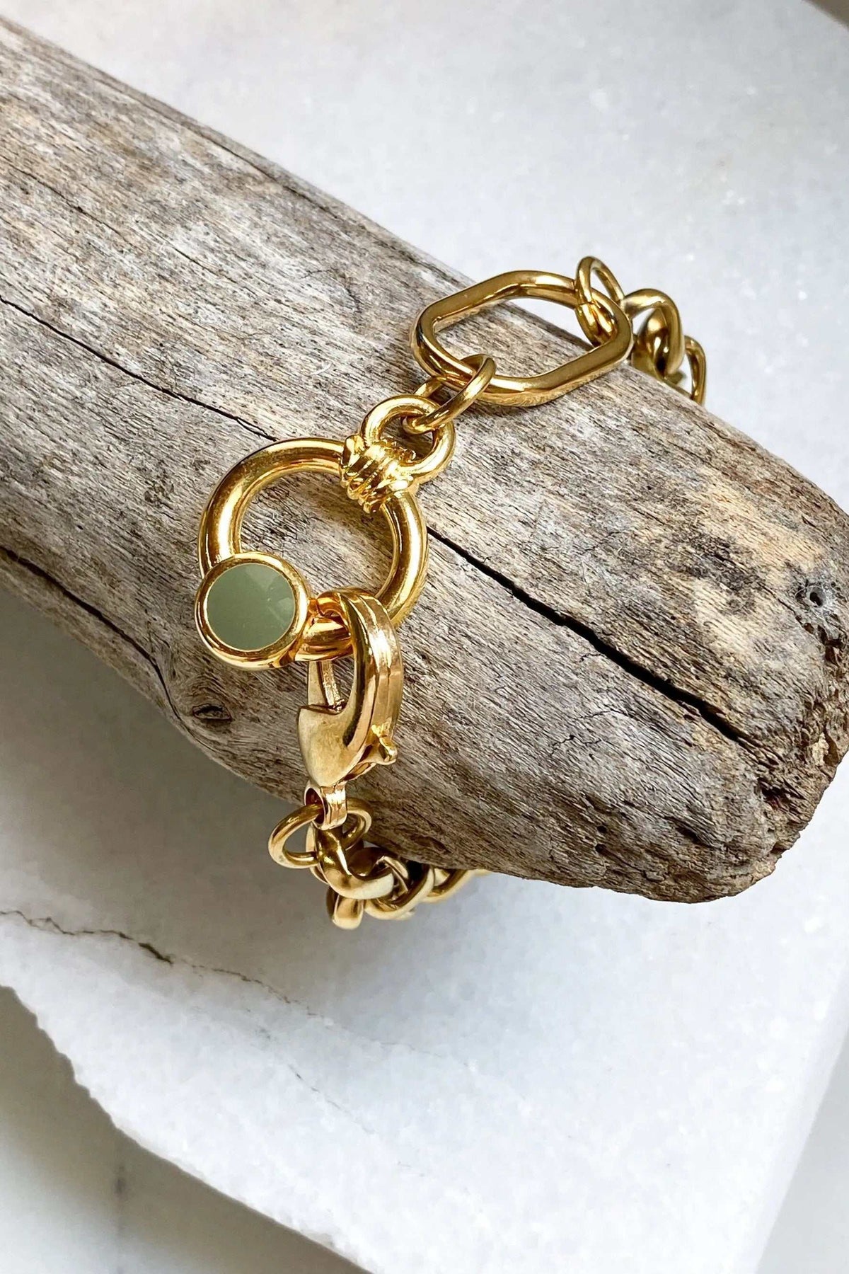 Gold Chain bracelet in glossy gold-tone metal with oversized links, a circular pale green charm and toggle clasp