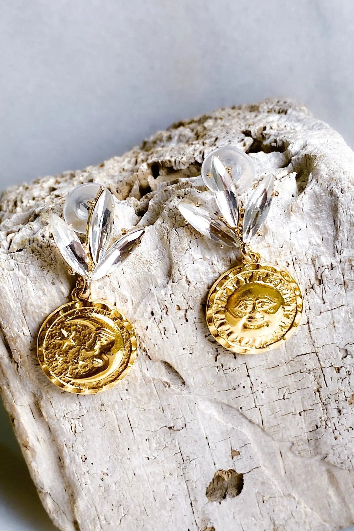 Gold Coin drop Earrings in gold-tone metal with embossed sun and moon coin charms and clear crystal leaf studs.