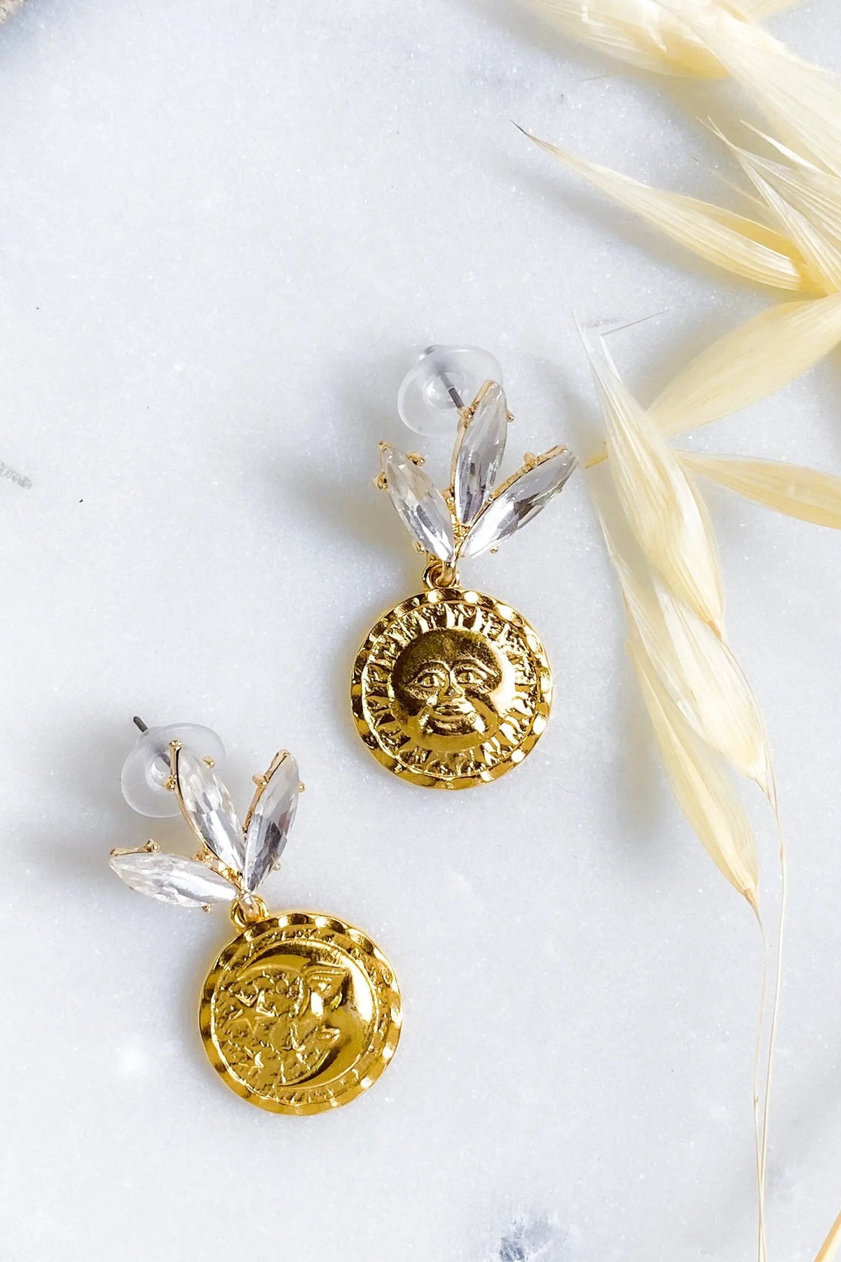 Gold Coin drop Earrings with textured gold sun and moon coin charms beneath clear crystal leaf-shaped studs.