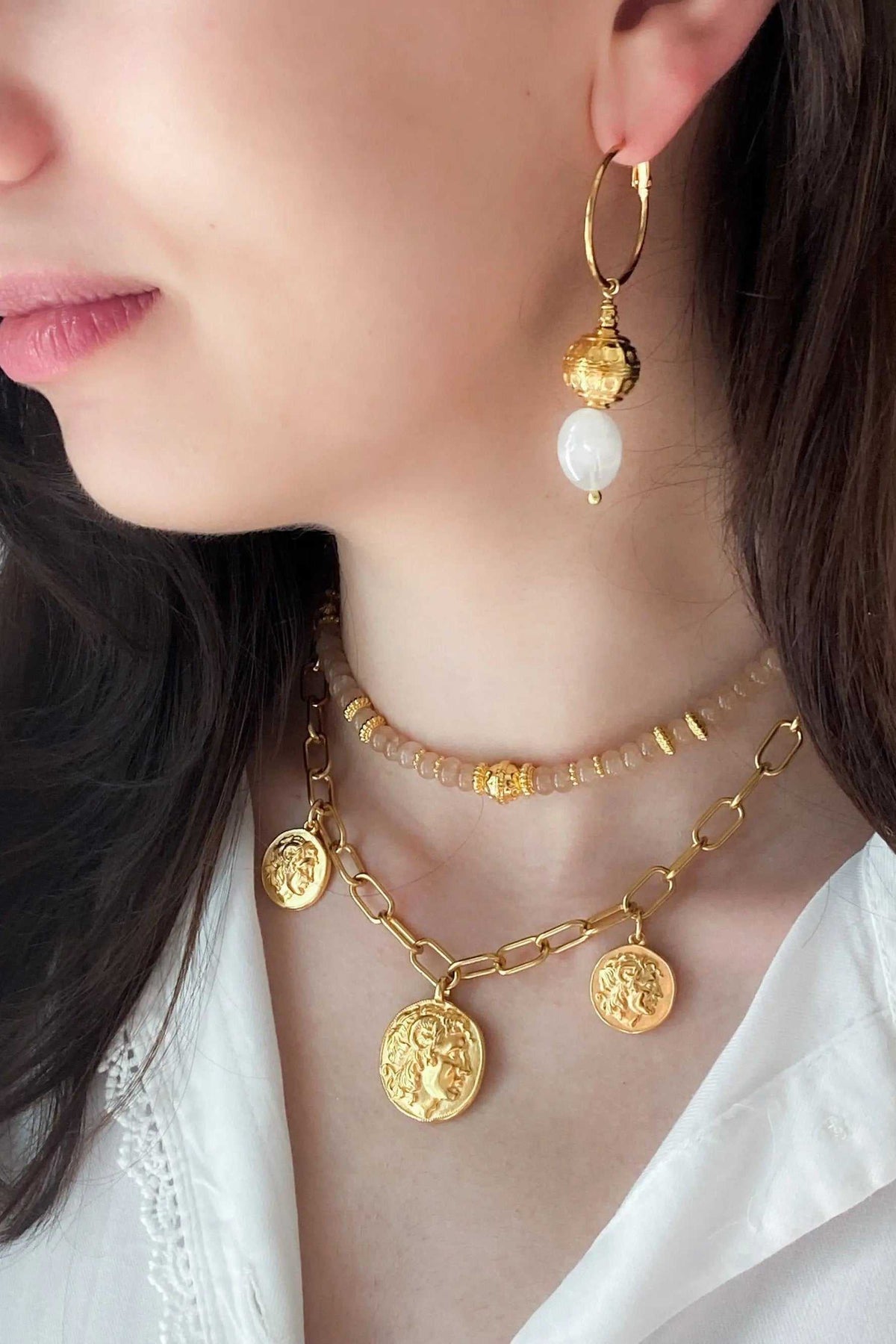 Gold Coin Necklace in gold-tone metal with layered chains and engraved coin pendants, worn with matching earrings