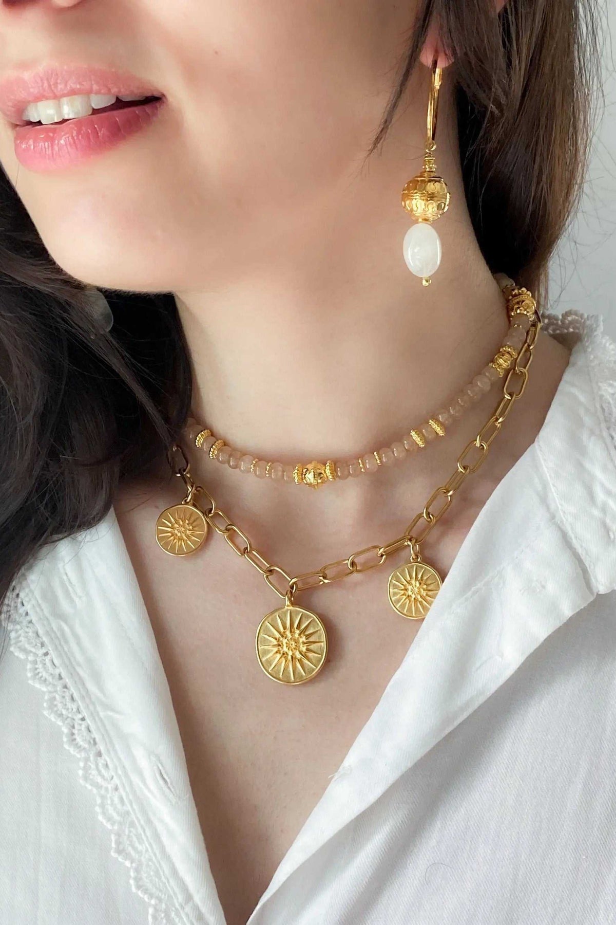 Gold Coin Necklace in gold-toned metal with two layered chains and sunburst coin pendants, styled with matching earrings