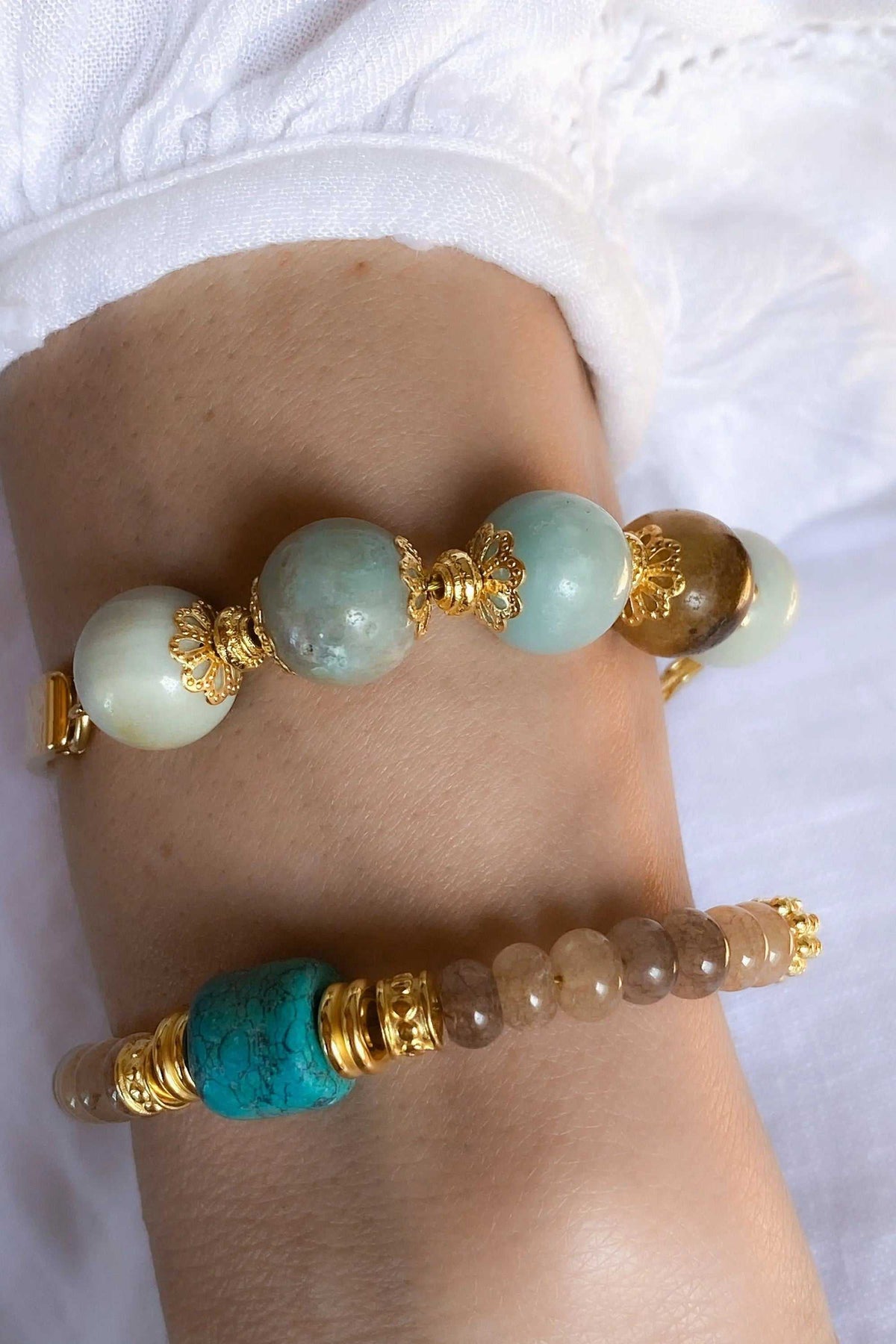 Gold cuff bracelet with gold-tone accents and round amazonite beads in pale blue, turquoise, cream, and brown