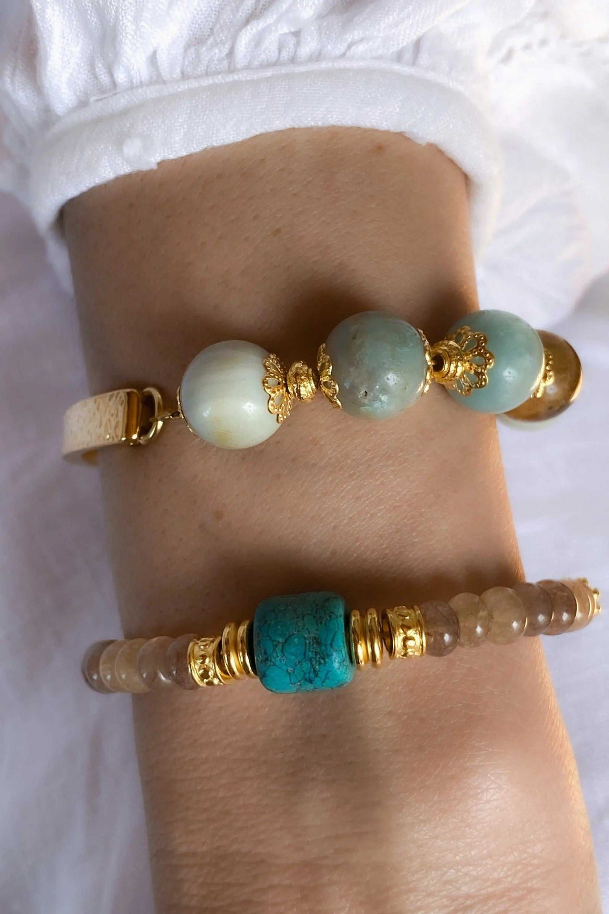 Gold cuff bracelet with pale blue and turquoise stone beads, gold-toned metal accents and an open half-cuff design