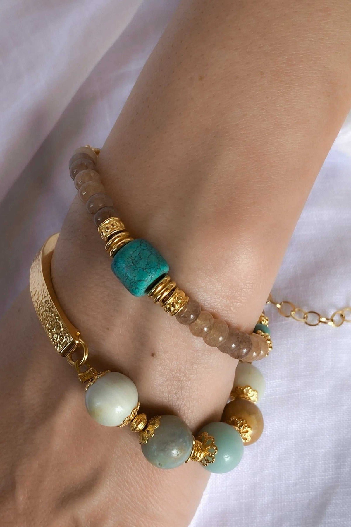 Gold cuff bracelet with an engraved gold-tone band, turquoise and pale aqua beads, and gold accents
