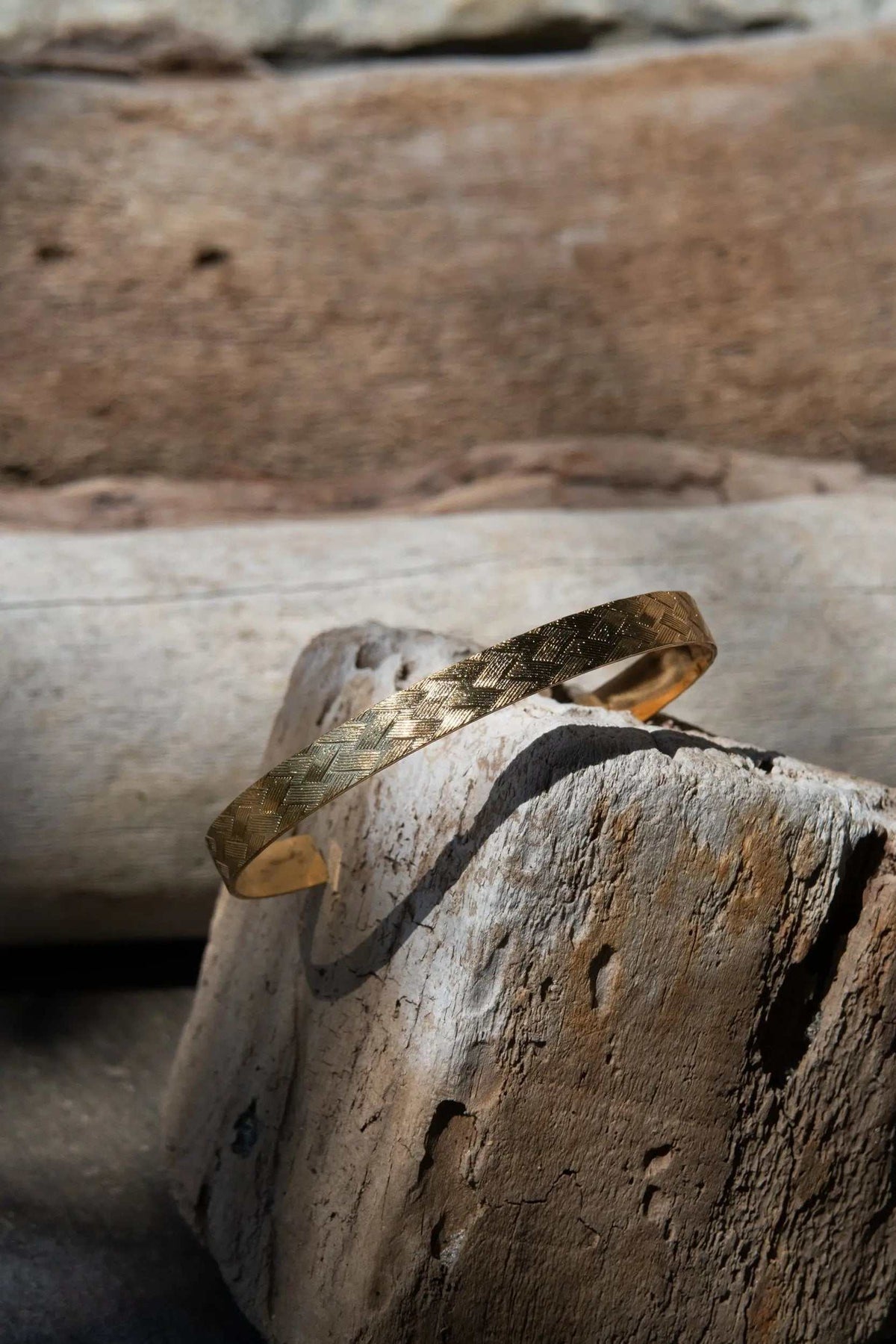 Gold elegant Cuff Bracelet with a warm gold-tone finish and an engraved repeating straw-like pattern on a slim open band