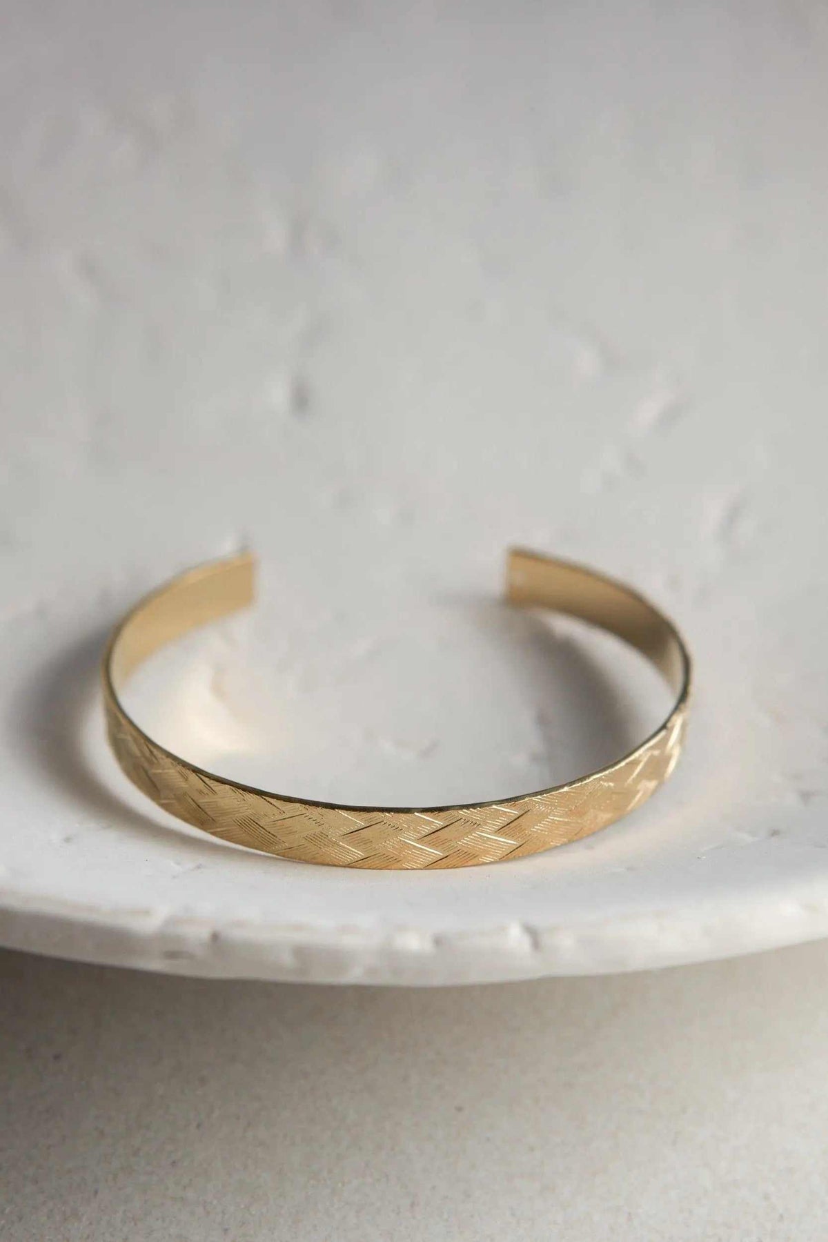 Gold elegant Cuff Bracelet in a warm gold-tone finish with a delicate woven straw pattern and open adjustable design
