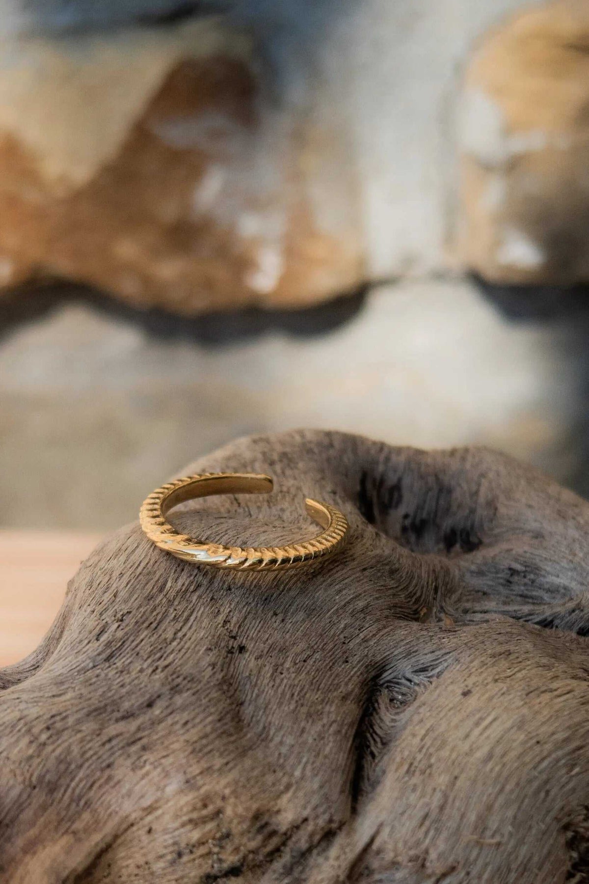 Gold filled band ring in gold-tone metal with a delicate twisted rope pattern and open adjustable shape