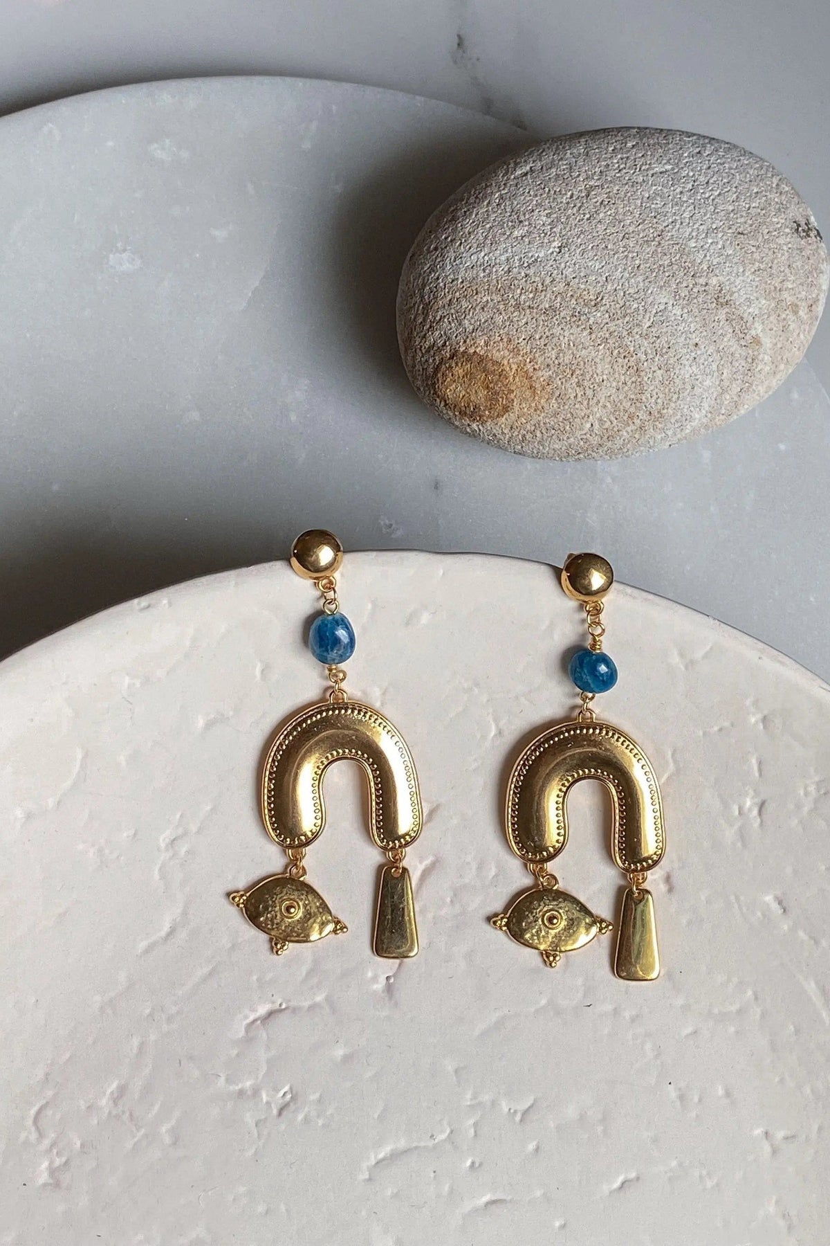 Gold Gypsy Earrings with blue beads and ornate gold-tone horseshoe arches, fish charms and dangling geometric drops