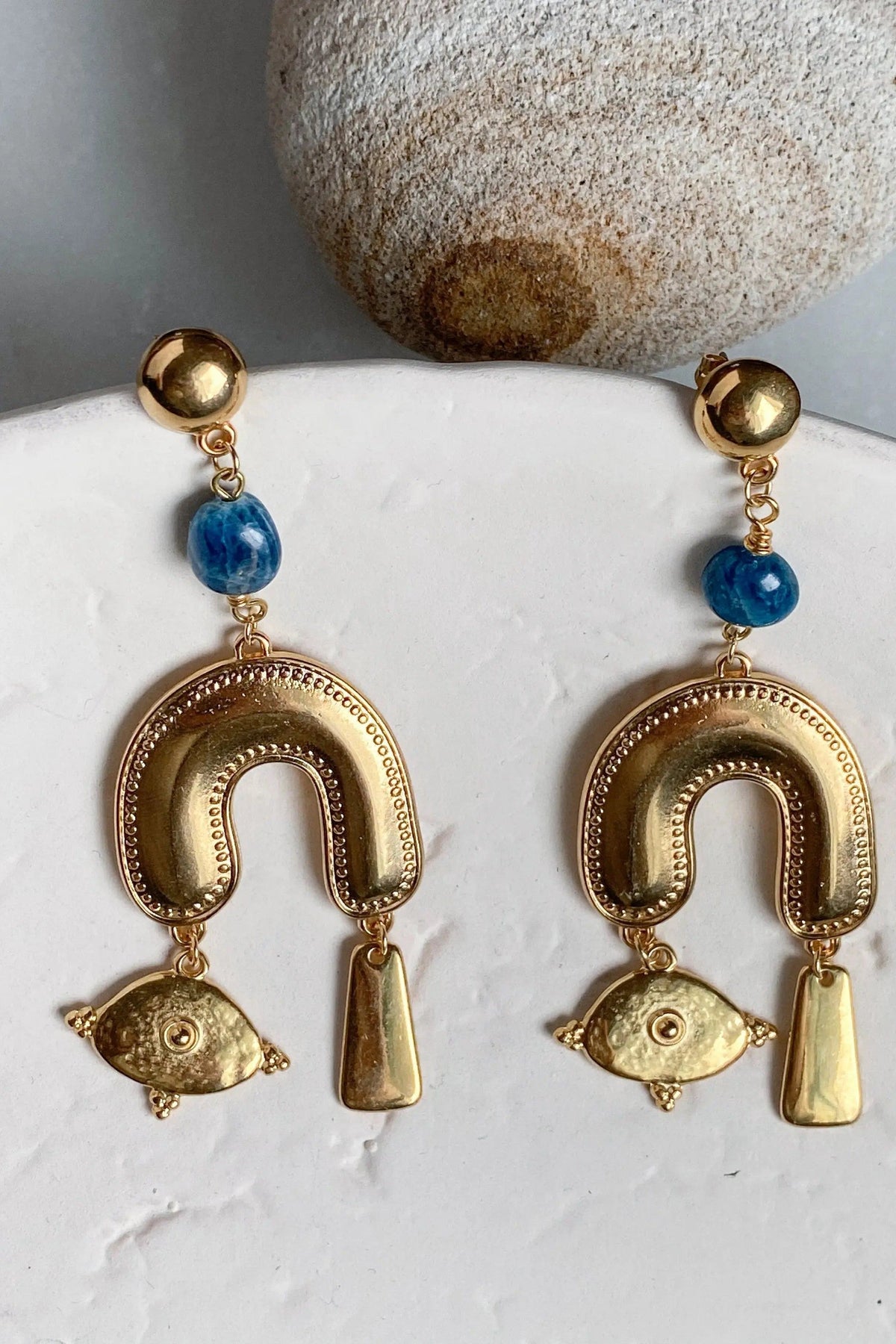 Gold Gypsy Earrings with gold-tone brass hoops, blue stone accents, and dangling eye and bar charms
