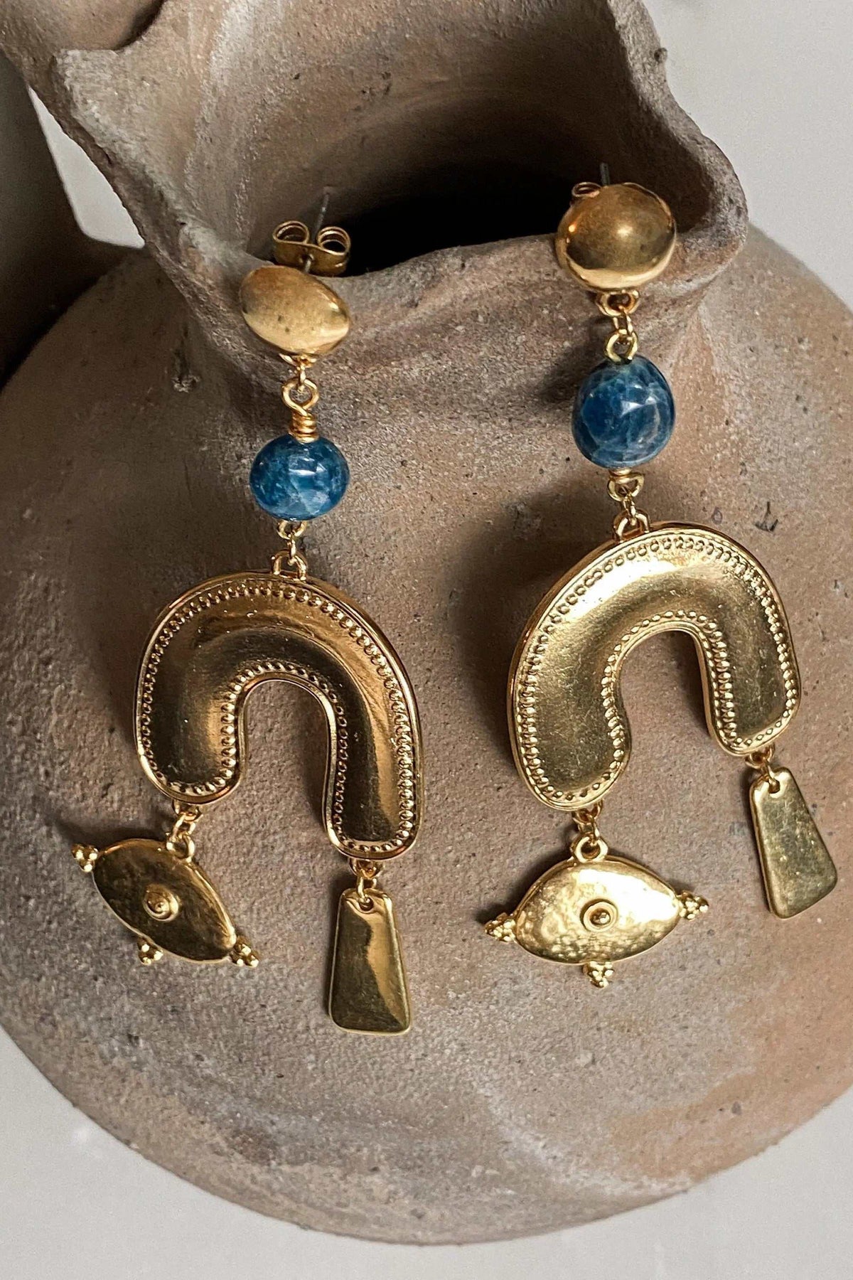 Gold Gypsy Earrings with gold-tone brass, round blue beads, textured horseshoe shapes, and dangling fish charms
