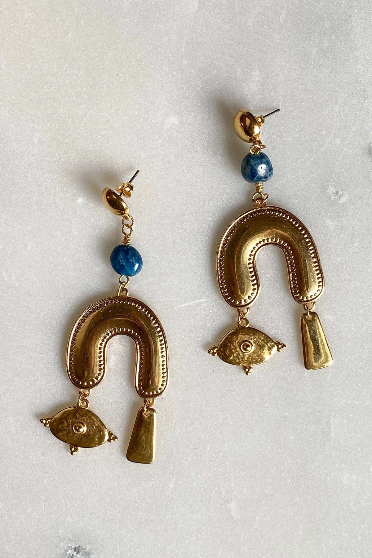 Gold Gypsy Earrings in gold-tone metal with blue round beads, textured horseshoe hoops, and dangling fish and bars